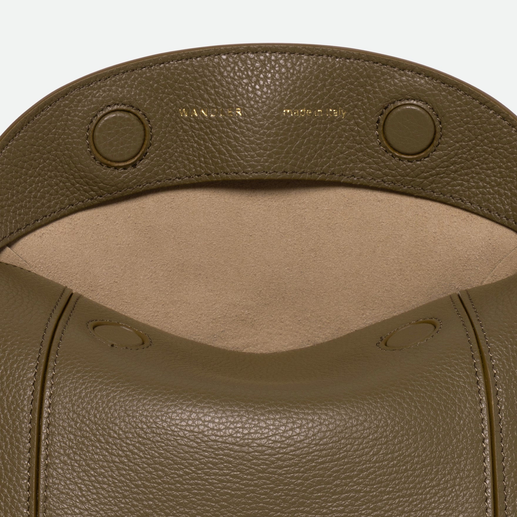 Wandler Penelope Slouch Bag in the color Olive Crust, green, made from smooth calf leather with golden hardware and adjustable slim strap. The bag is pictured from the front. The bag is pictured from the front with the flap open, giving a slight view of the inside of the bag.