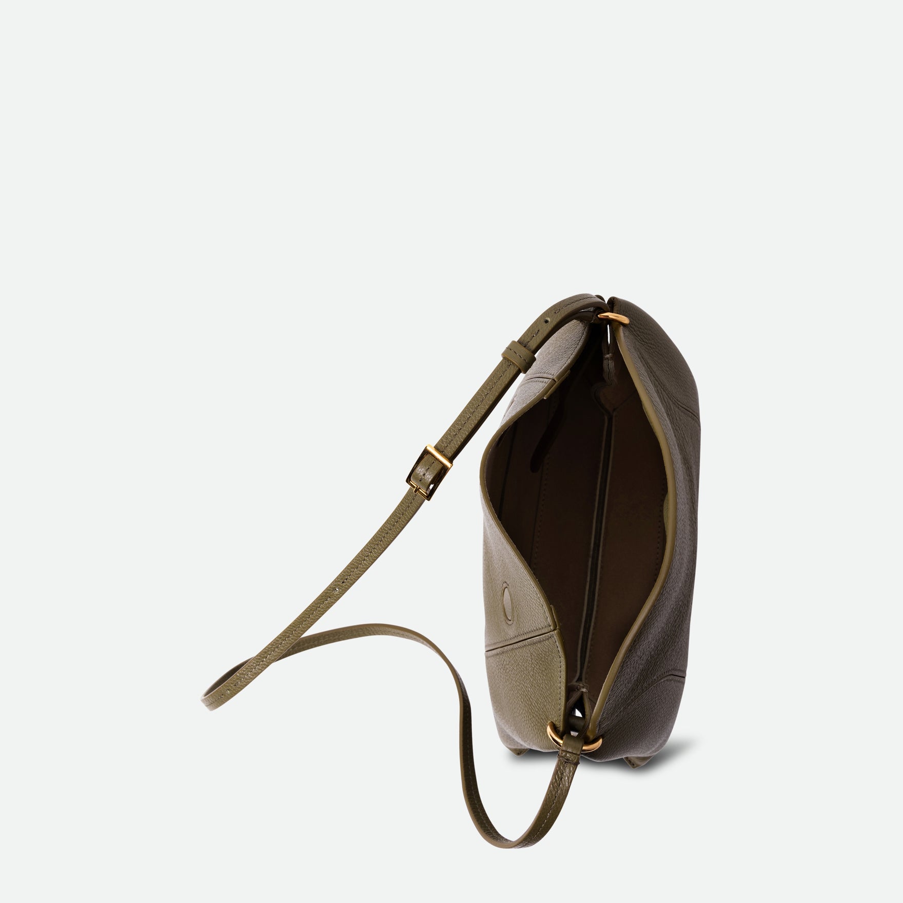 Wandler Penelope Slouch Bag in the color Olive Crust, green, made from smooth calf leather with golden hardware and adjustable slim strap. The bag is pictured from above, showing the inside of the bag. 