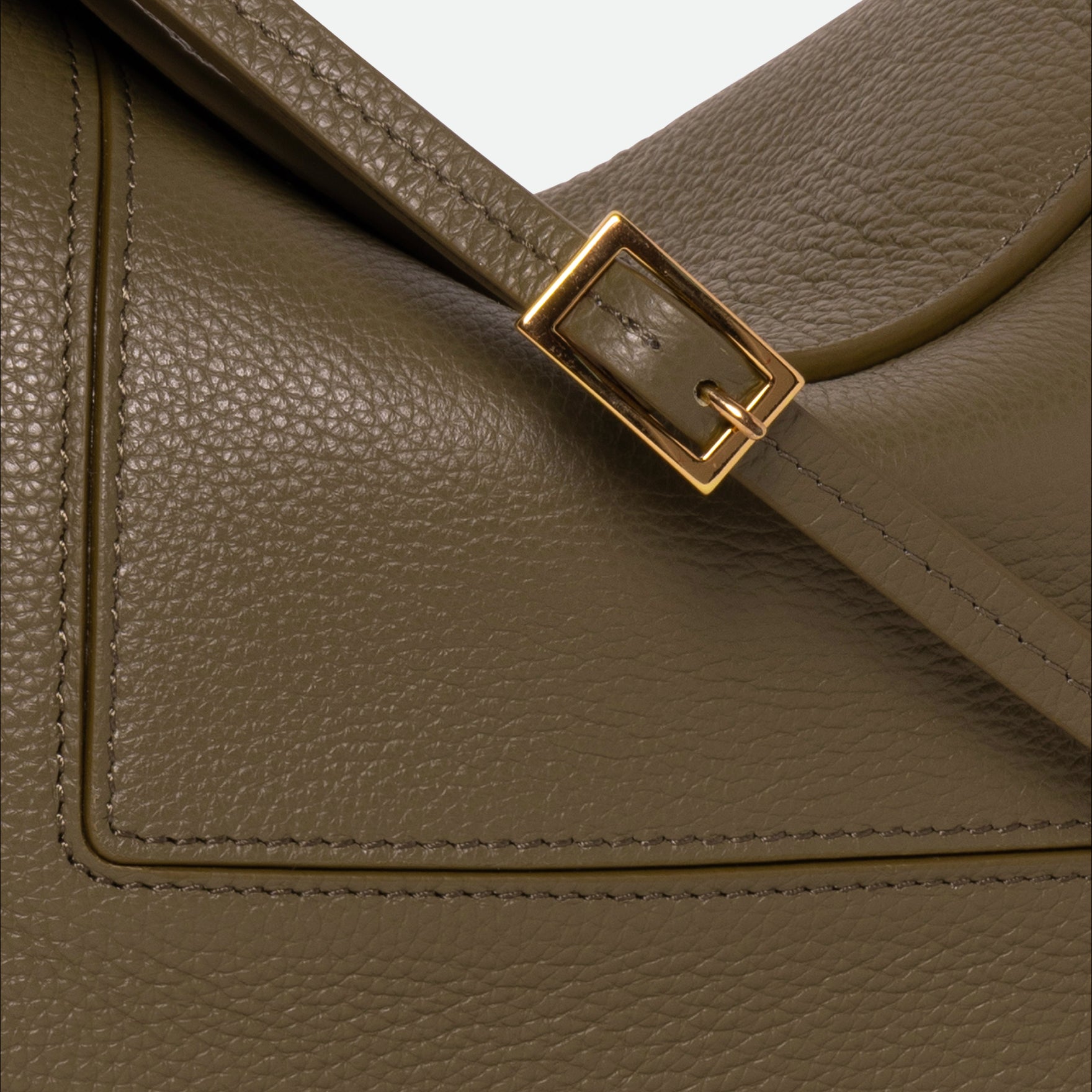 Wandler Penelope Slouch Bag in the color Olive Crust, green, made from smooth calf leather with golden hardware and adjustable slim strap, close up detailing the buckle, strap and leather.