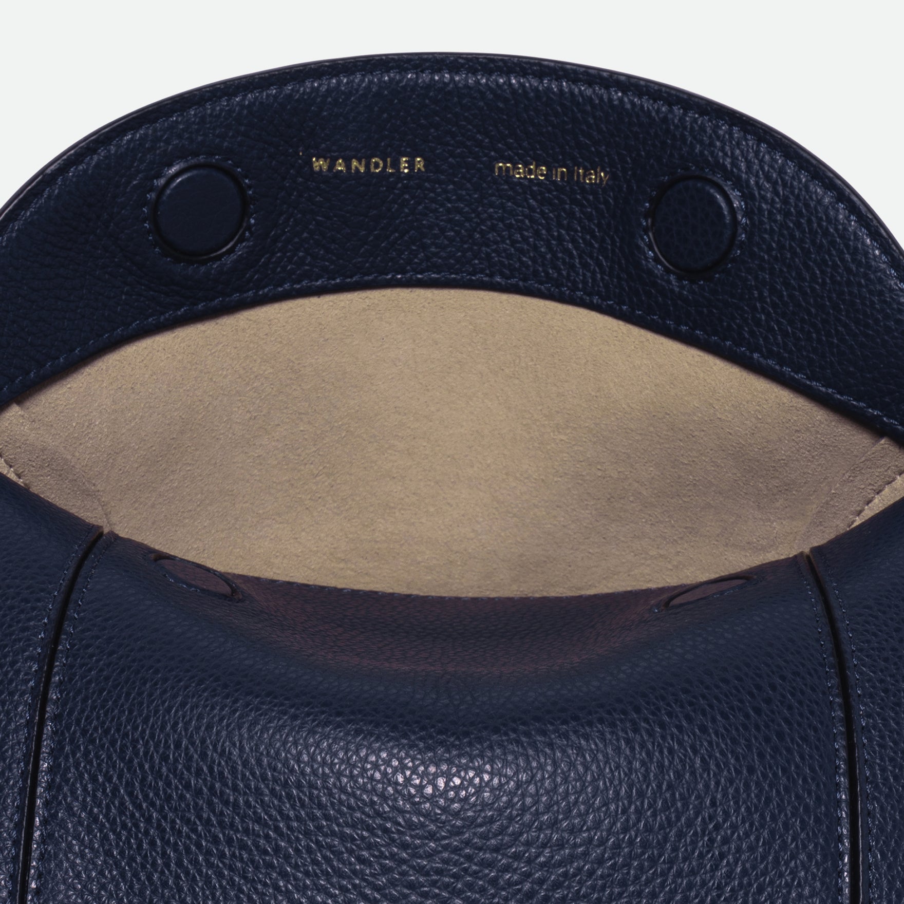 Wandler Penelope Slouch Bag in the color Orion Crust deep dark blue, made from calf leather with golden hardware and adjustable slim strap, close up detailing the logo and leather. 