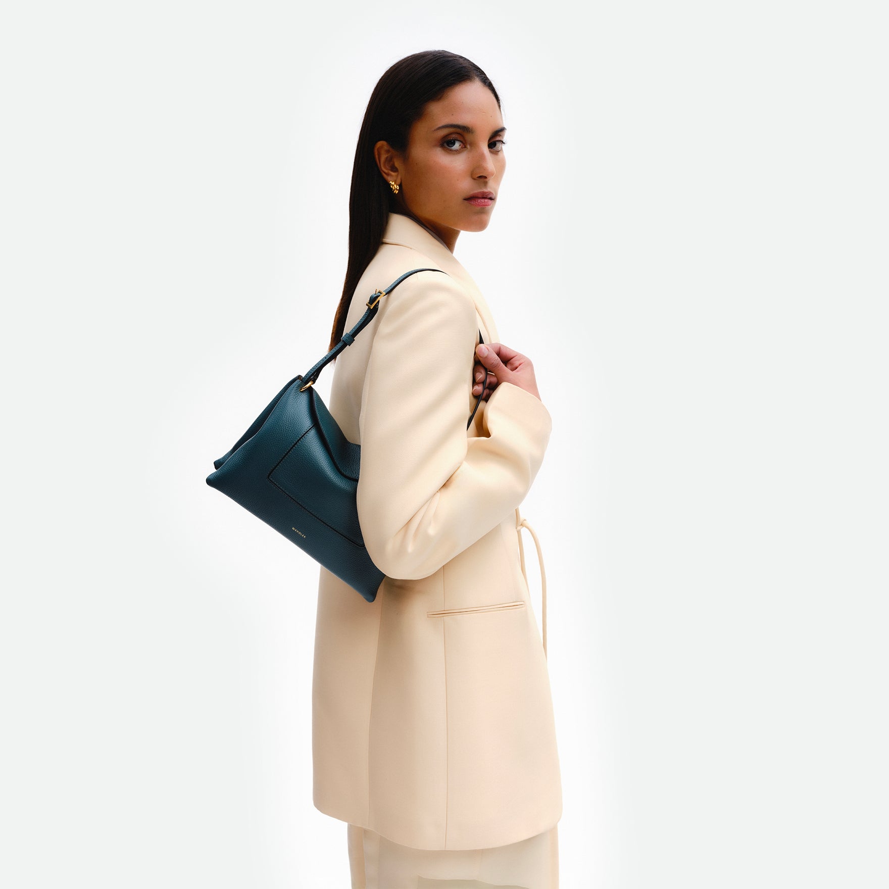 Wandler Penelope Slouch Bag in the color Teal Crust made from calf leather with golden hardware and adjustable slim strap, pictured on model.