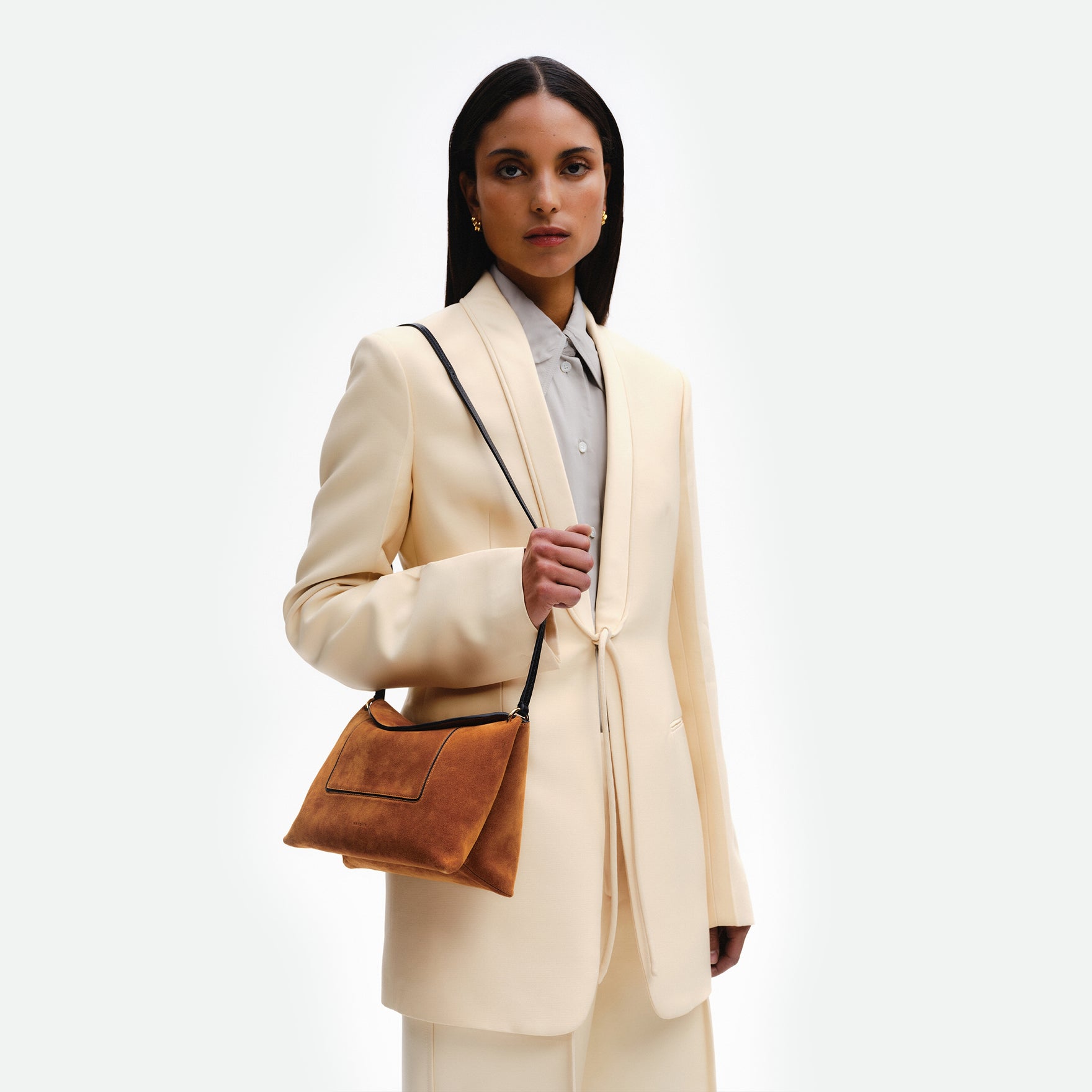 Wandler Penelope Slouch Bag in the color Cognac Suede, made from calf leather with golden hardware and adjustable slim strap, pictured being worn on the shoulder by model.