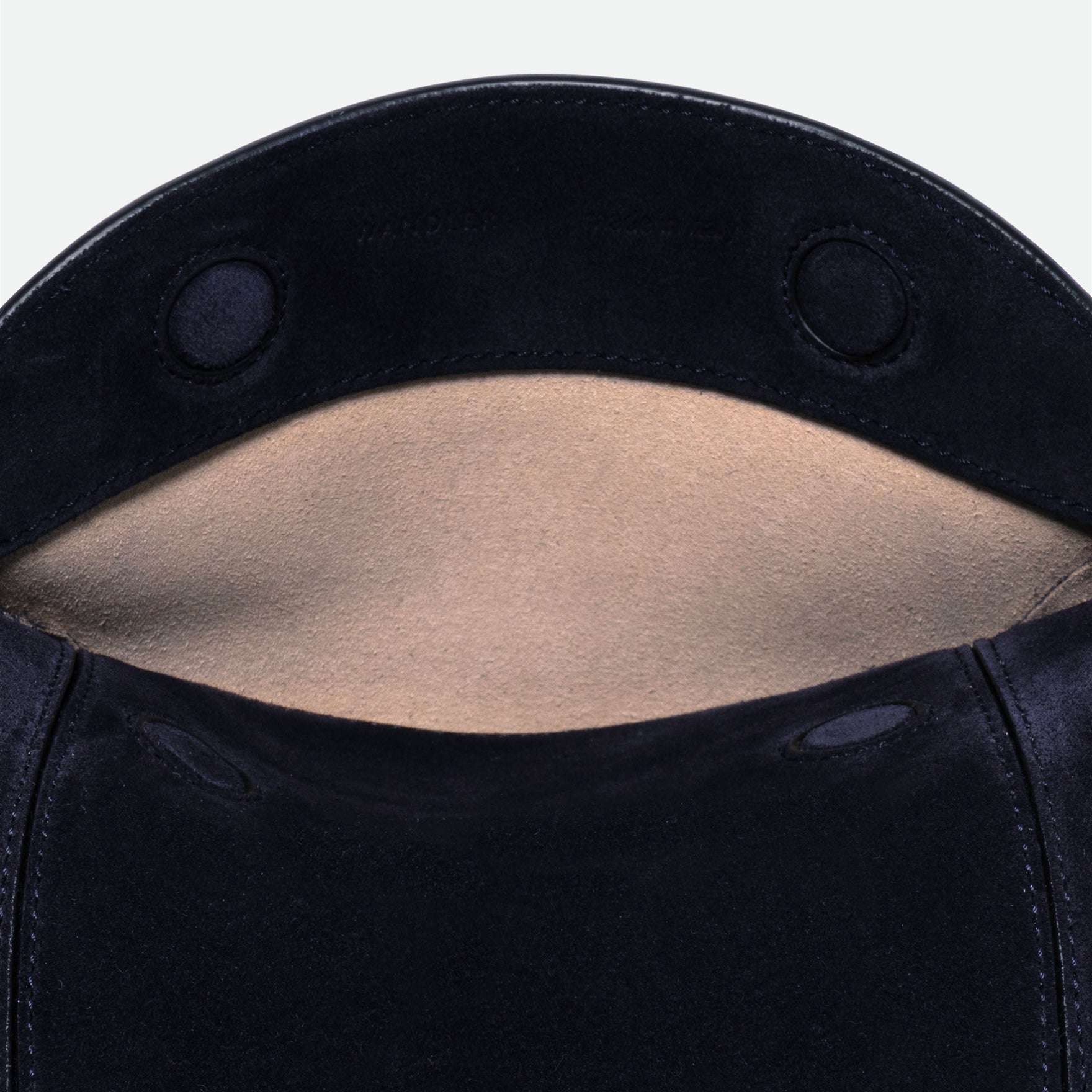 Wandler Penelope Slouch Bag in the color Orion Suede, deep dark blue, made from calf leather with golden hardware and adjustable slim strap, close up detailing the logo and leather. 