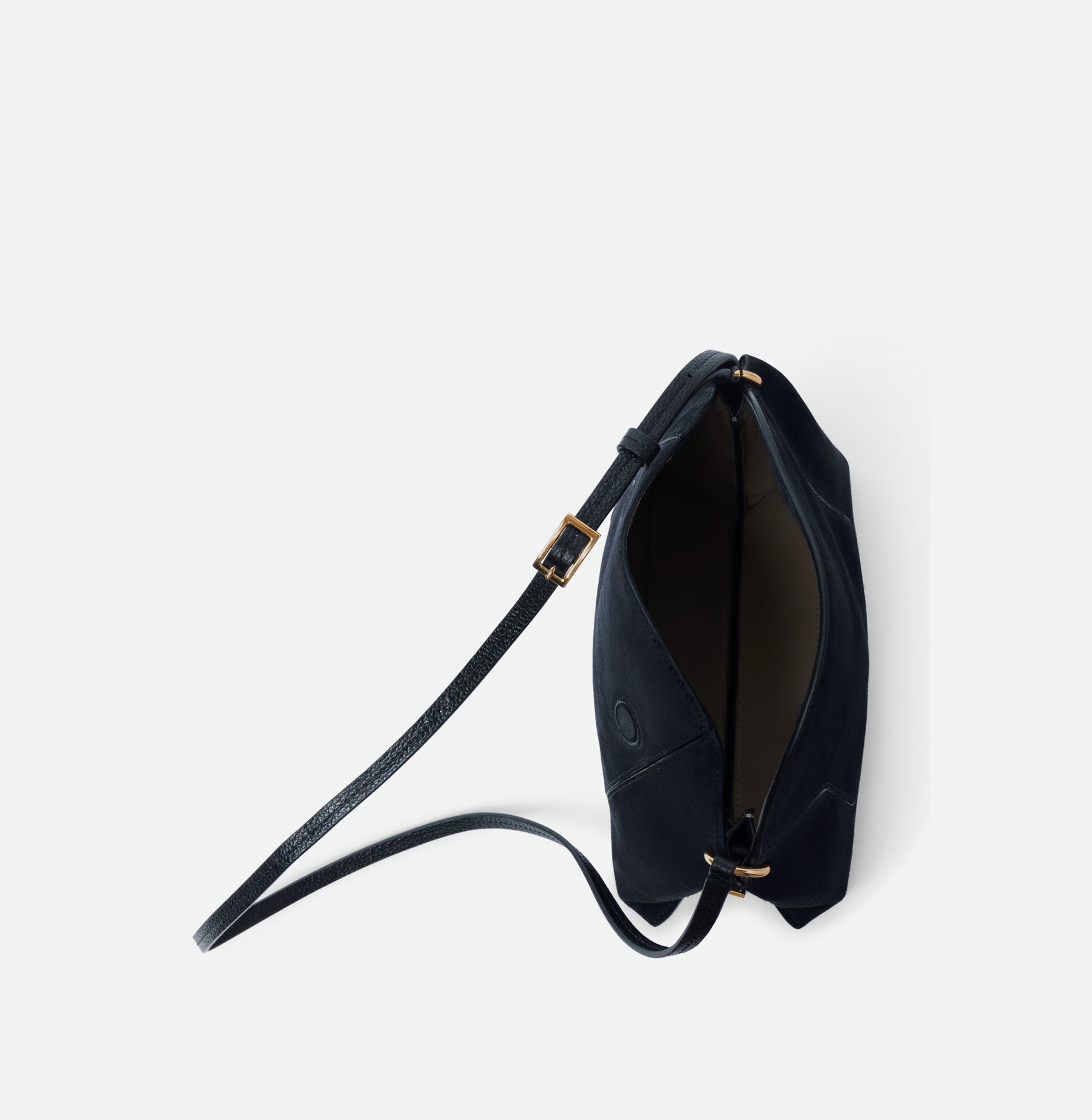 Wandler Penelope Slouch Bag in the color Orion Suede, deep dark blue, made from calf leather with golden hardware and adjustable slim strap, pictured with the zipper and flap open, giving a glimpse into the inside of the bag. 