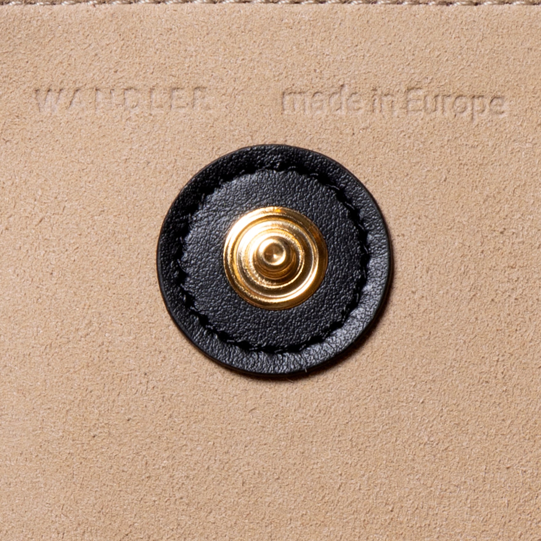 Wandler Penny Tote in the color Grape, made from Italian calf leather with hand-painted black edges and golden hardware, close up detailing button closure and logo.