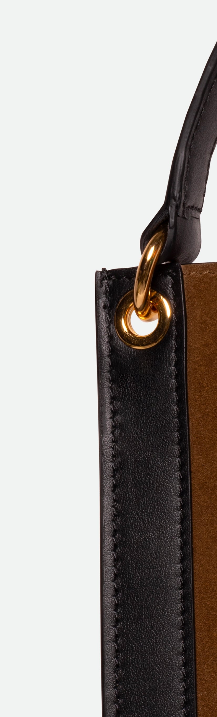 Wandler Penny Tote in the color Tabacco Suede, made from Italian calf leather with hand-painted black edges and golden hardware, close up detailing the leather and strap attachment.