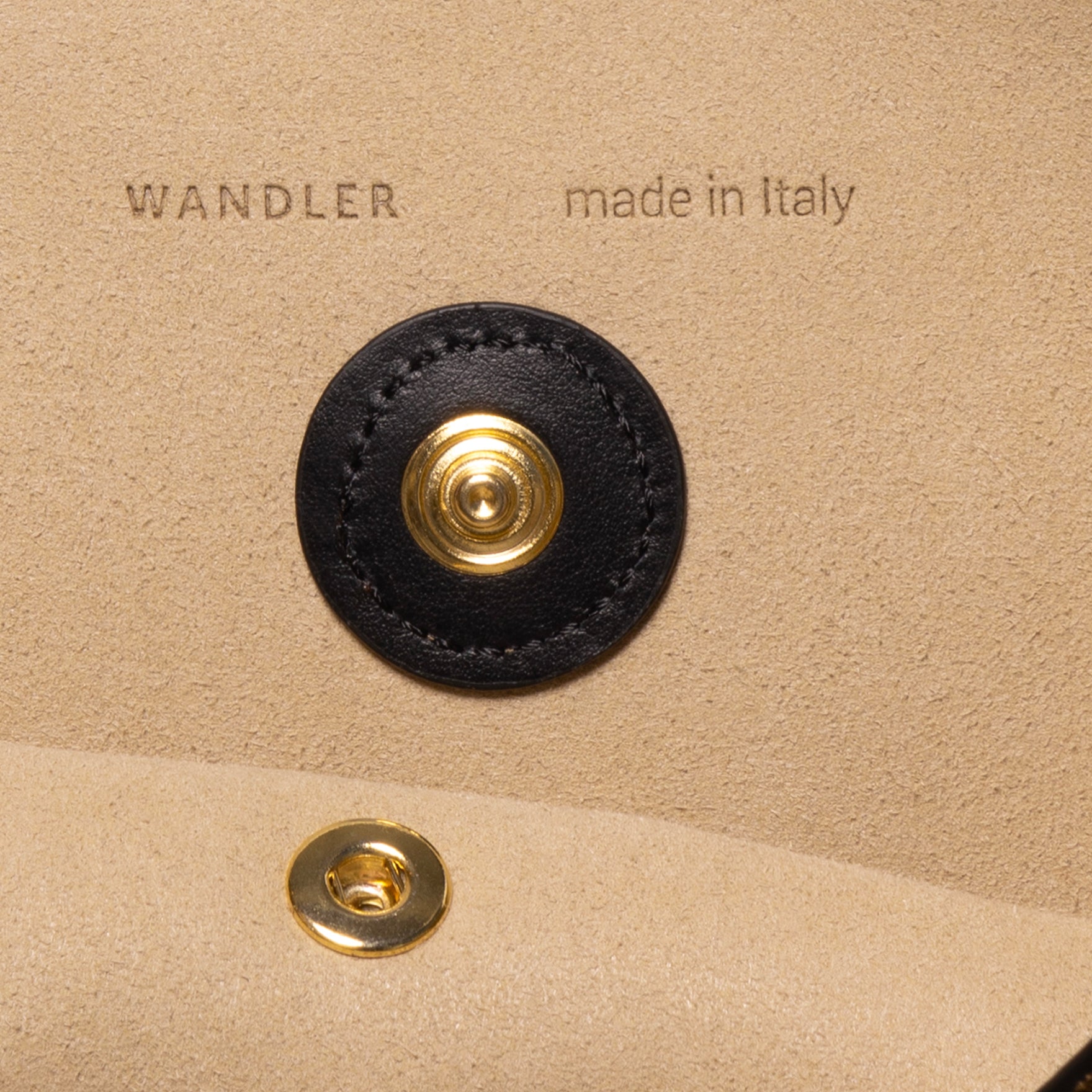 Wandler Penny Tote in the color Tabacco Suede, made from Italian calf leather with hand-painted black edges and golden hardware, close up detailing button closure.