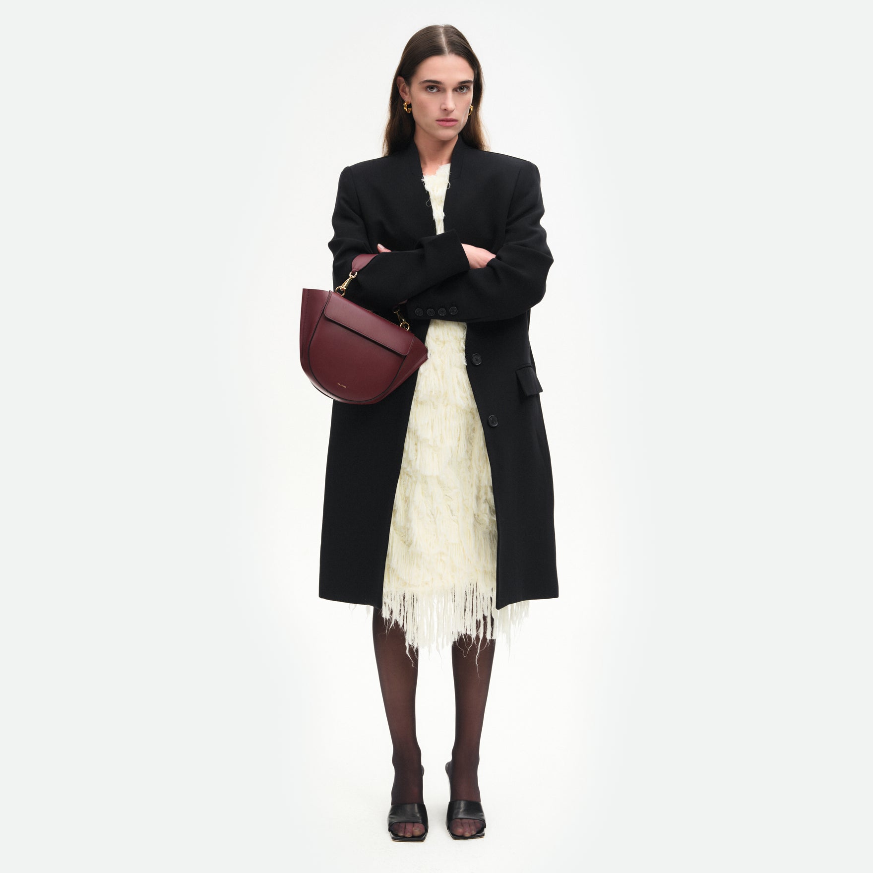 Wandler Hortensia Bag Mini in the color Acai, made from Italian calf leather with golden hardware, rounded silhouette and top handle, pictured on model, worn on the forearm, full body picture.