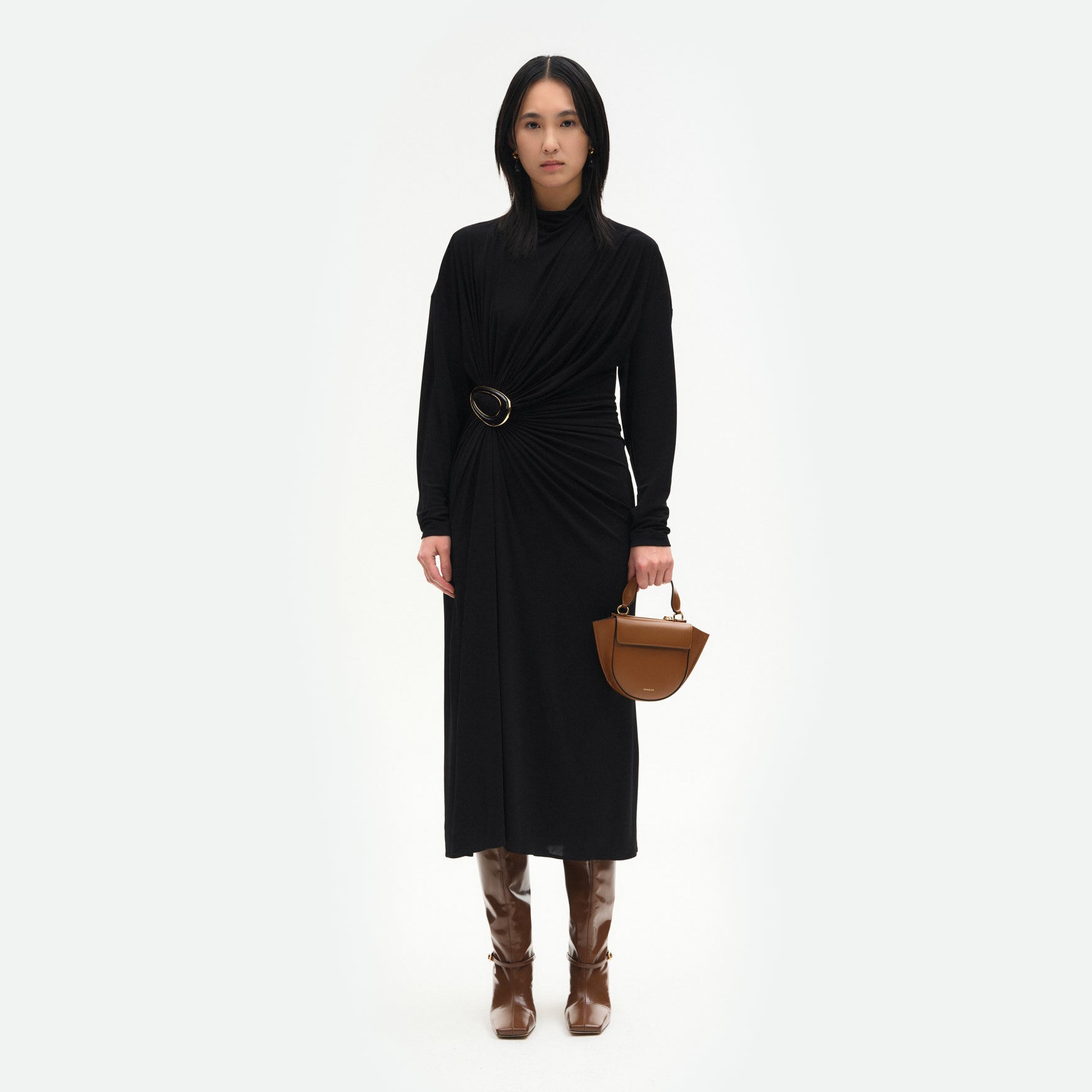 Wandler Hortensia Bag Piccola in the color Saddle, warm brown, Italian calf leather with golden hardware, rounded silhouette and top handle, pictured being hand-held by model. 