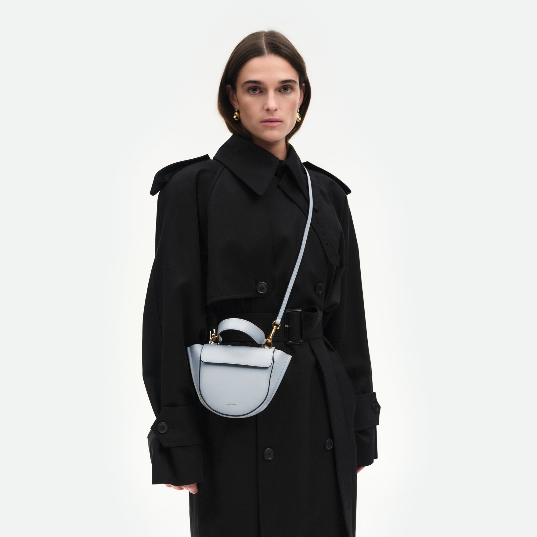Wandler Hortensia Bag Piccola in the color  Steel, cold grey, made from Italian calf leather with golden hardware and rounded silhouette, pictured on model, worn in crossbody style.