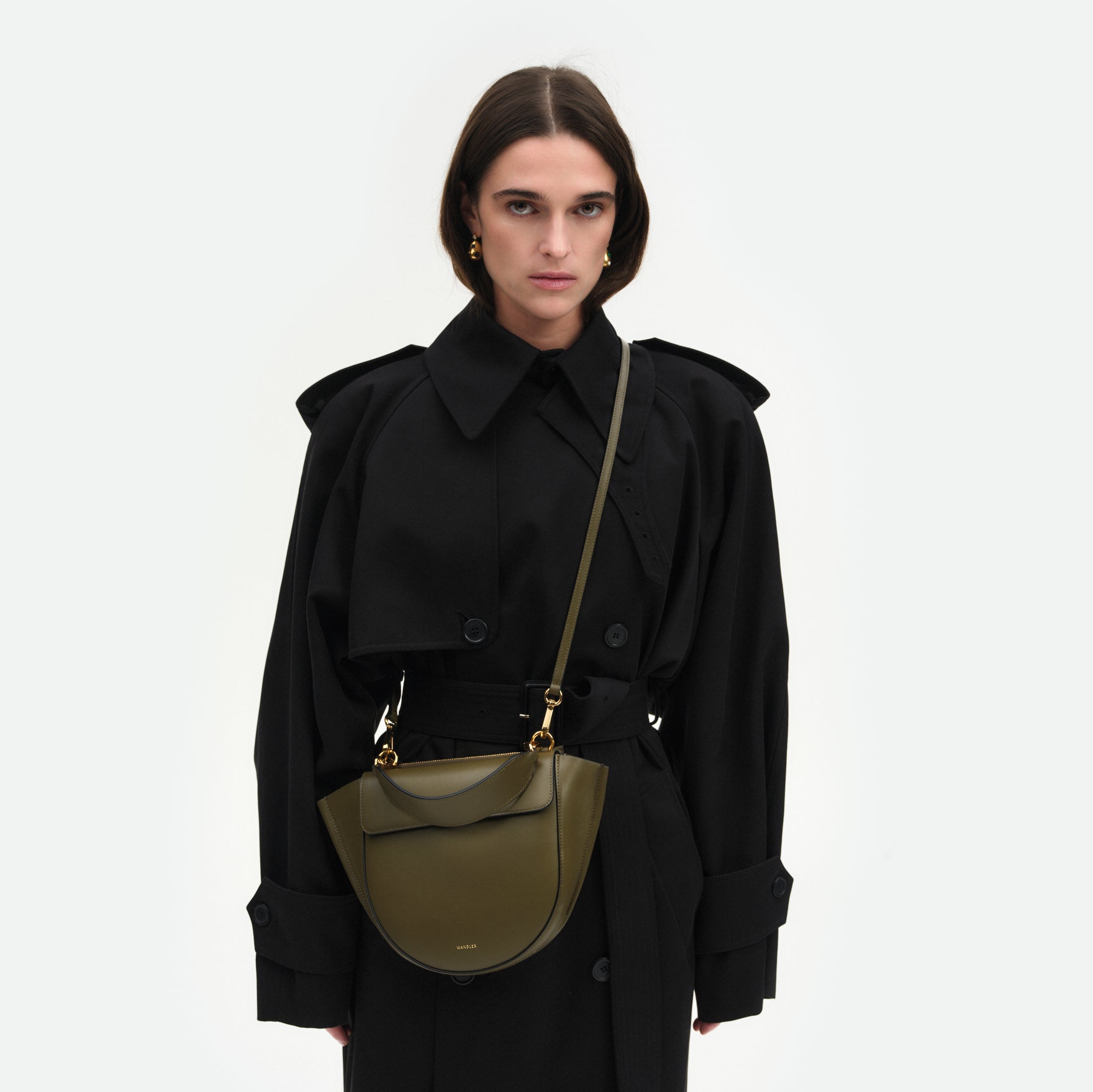 Wandler Hortensia Bag Small in the color Deep Olive, dark green, Italian calf leather with golden hardware and rounded silhouette, pictured on model styled as a crossbody bag.