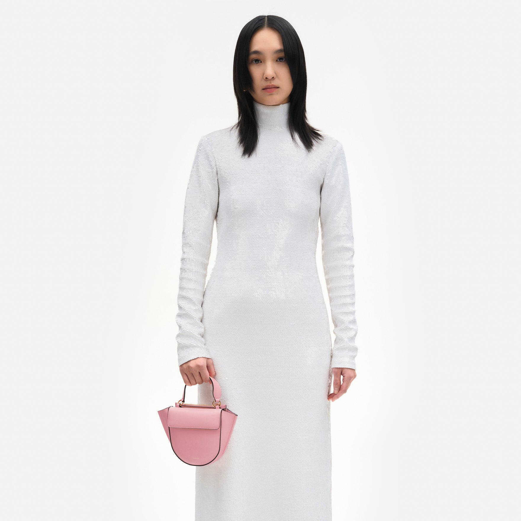 Wandler Hortensia Bag Piccola in the color Primrose made from Italian calf leather with golden hardware and rounded silhouette, pictured being hand-held by model.