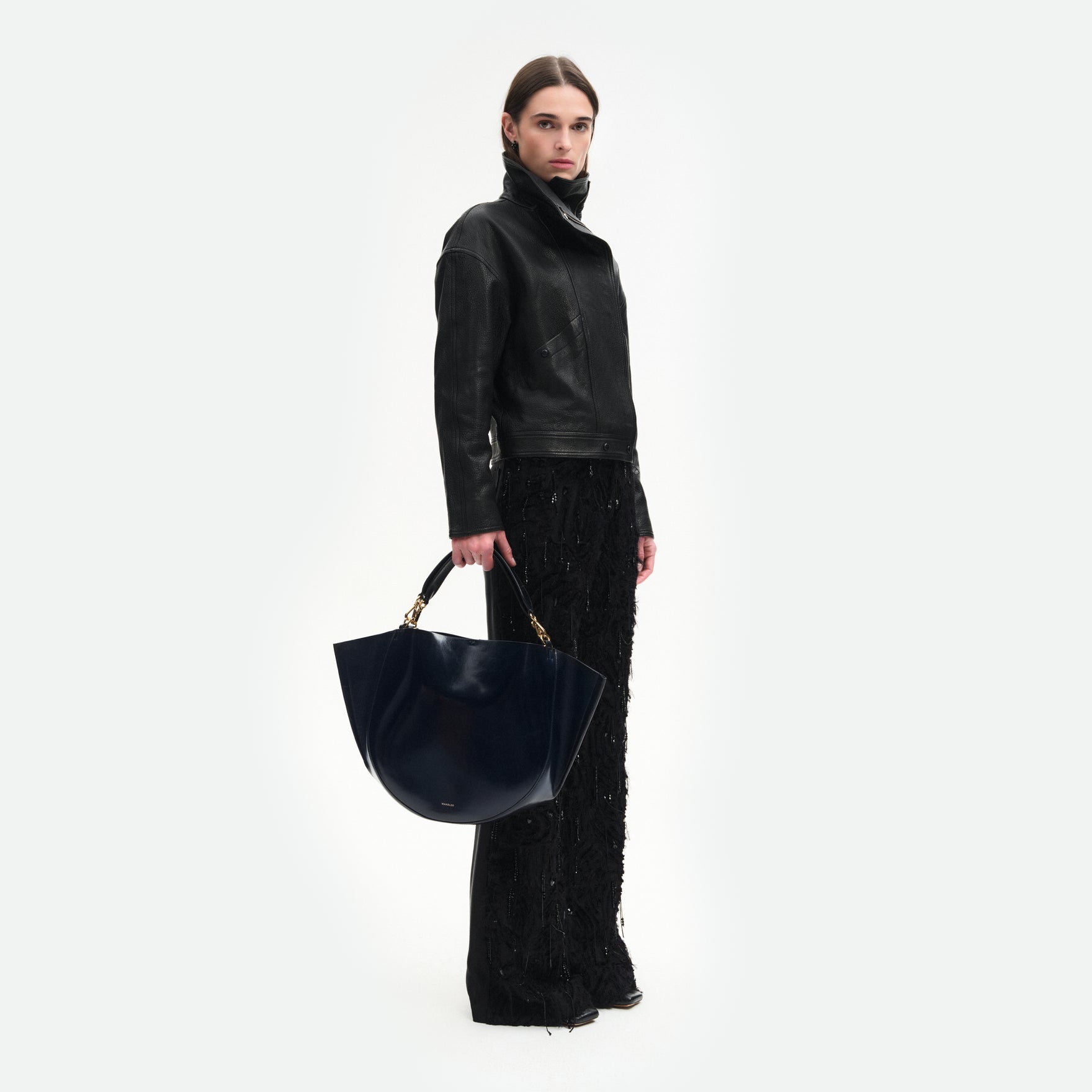 Wandler Hortensia Tote in Orion Glaze Italian calf leather with golden hardware, hand-painted edges and rounded silhouette, pictured on being handheld by model.