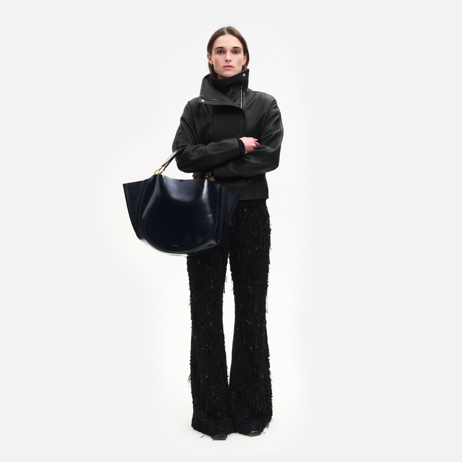 Wandler Hortensia Tote in Orion Glaze Italian calf leather with golden hardware, hand-painted edges and rounded silhouette, pictured being carried on the fore-arm by model.