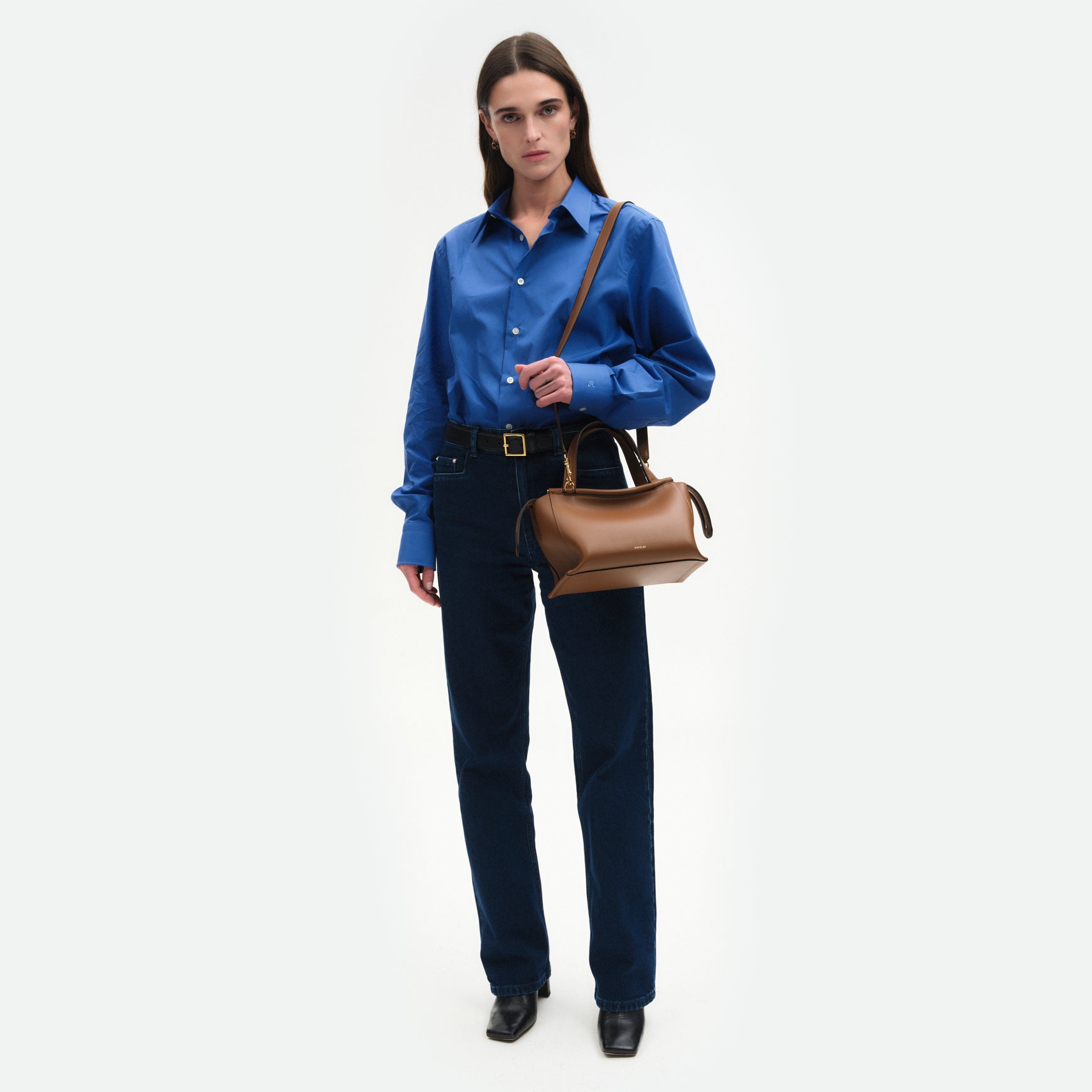 Wandler Ida Bag in the color Saddle, warm brown, made from Italian calf leather with golden hardware and sculptural top handle, pictured on model, worn on shoulder, full body picture. 