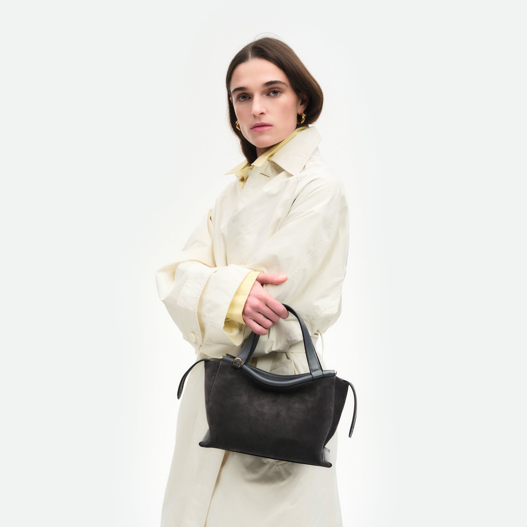 Wandler Ida Bag in the color Space Suede, made from Italian calf leather with golden hardware and sculptural top handle, pictured on model, worn on the forearm. 