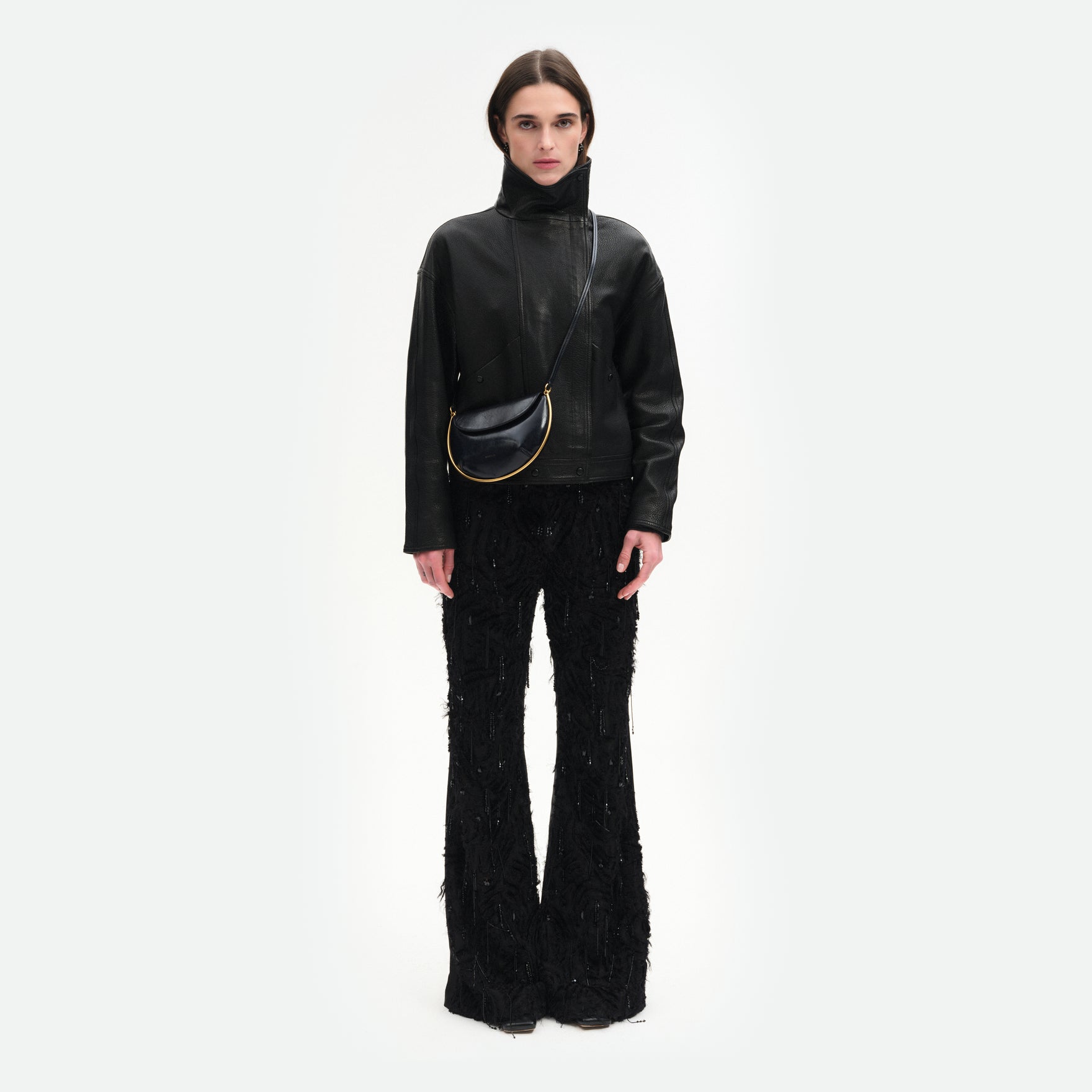 Wandler Kate Mini Crossbody in the color Orion Glaze, deep dark blue, made from Italian calf leather with golden hardware and adjustable strap, pictured on model, worn in crossbody style, full body picture. 