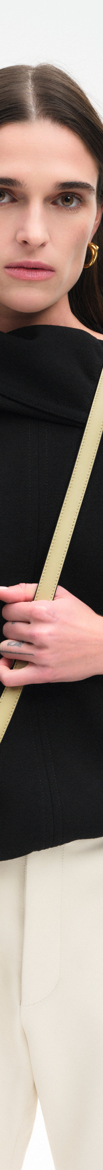 Wandler Veneto Crossbody Small in Peper, dark beige, made from Italian calf leather with golden clasp hardware and structured silhouette, pictured on model, worn in a crossbody style, half body picture. 