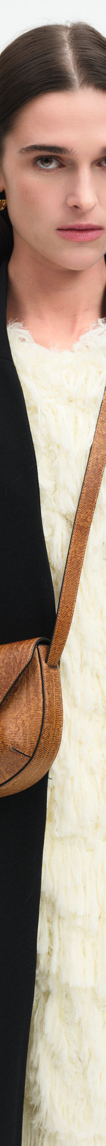 Wandler Veneto Crossbody Small in Tabacco Lizzard, warm brown with lizzard pattern, made from Italian calf leather with golden clasp hardware and structured silhouette, pictured on model, worn in crossbody style, half body picture. 