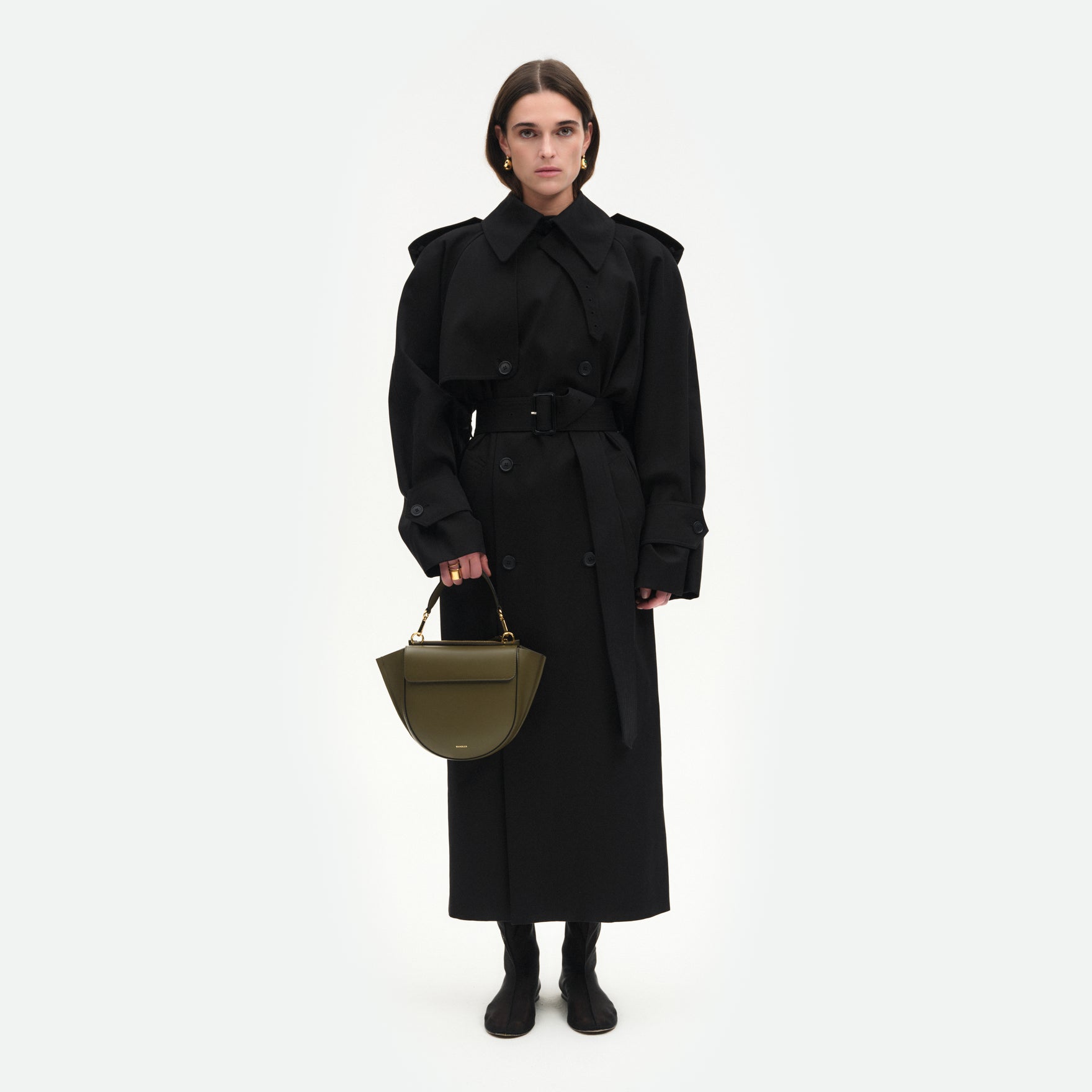 Wandler Hortensia Bag Small in the color Deep Olive, dark green, Italian calf leather with golden hardware and rounded silhouette, front view. Pictured being hand-held by model. 