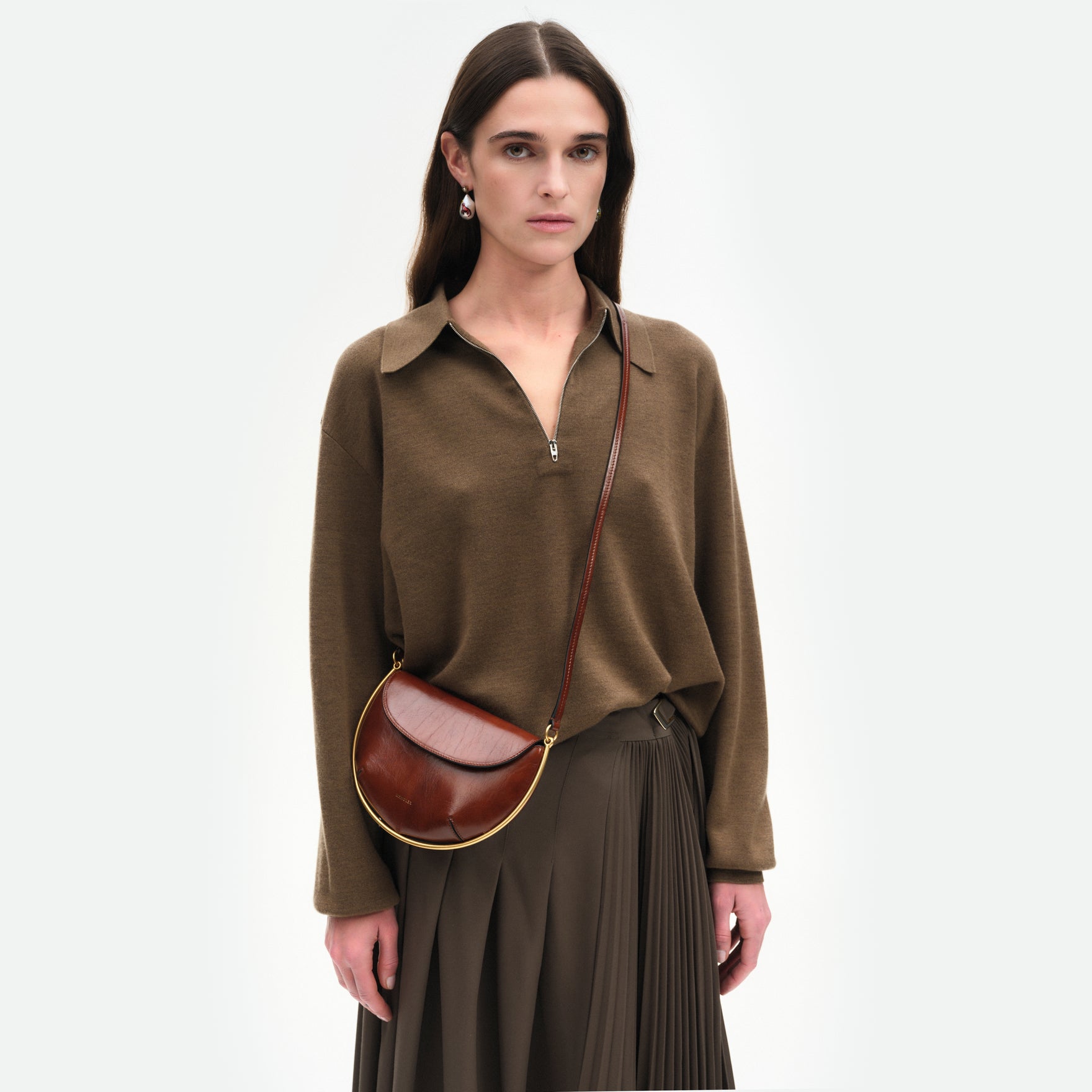 Wandler Kate Mini Crossbody in the color Palissander Glaze, Deep dark brown with red undertones, made from Italian calf leather with golden hardware and adjustable strap, pictured on model, worn in crossbody style, half body picture. 