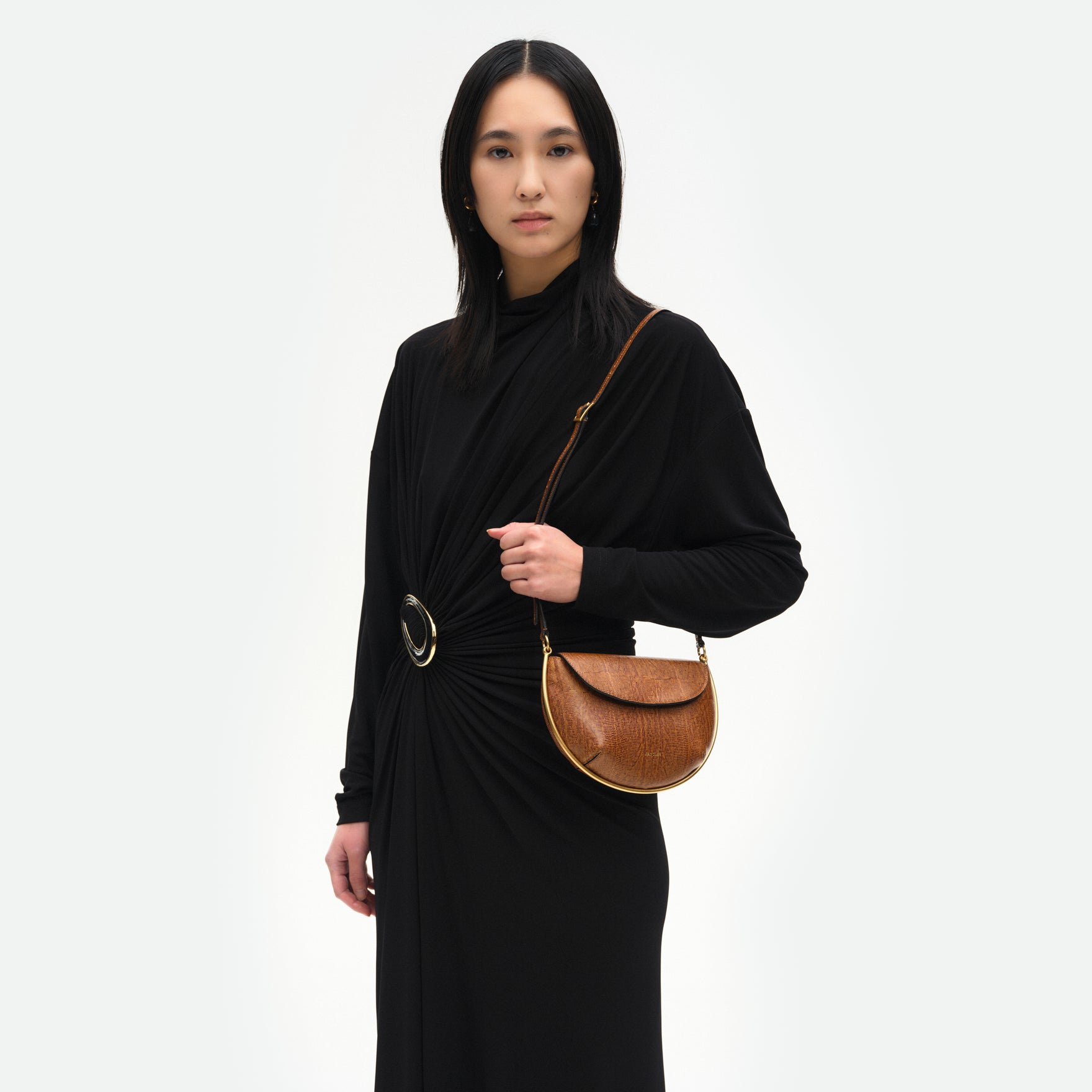 Wandler Kate Mini Crossbody in the color Tabacco Lizzard, Warm brown with lizzard motive, made from Italian calf leather with golden hardware and adjustable strap, pictured on model, worn in on the shoulder, half body picture. 