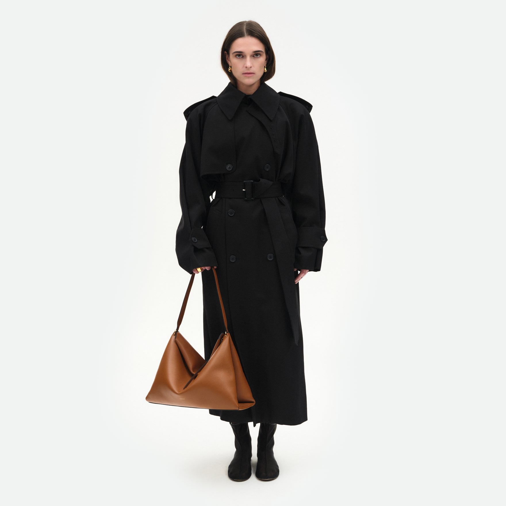 Wandler Penelope Tote in the color Tan Crust, made from Italian calf leather with golden hardware and soft structured silhouette, pictured being hand-held by model.