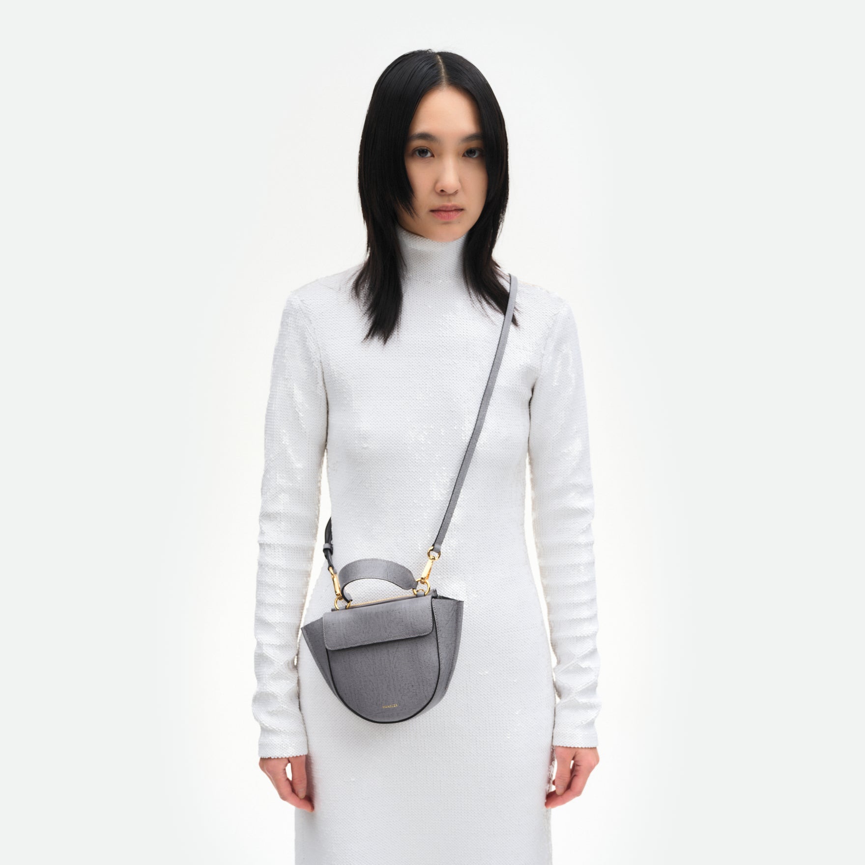 Wandler Hortensia Bag Piccola in the color  Grey Lizzard, grey with lizard motive, made from Italian calf leather with golden hardware and rounded silhouette, pictured on model, worn in a crossbody style.