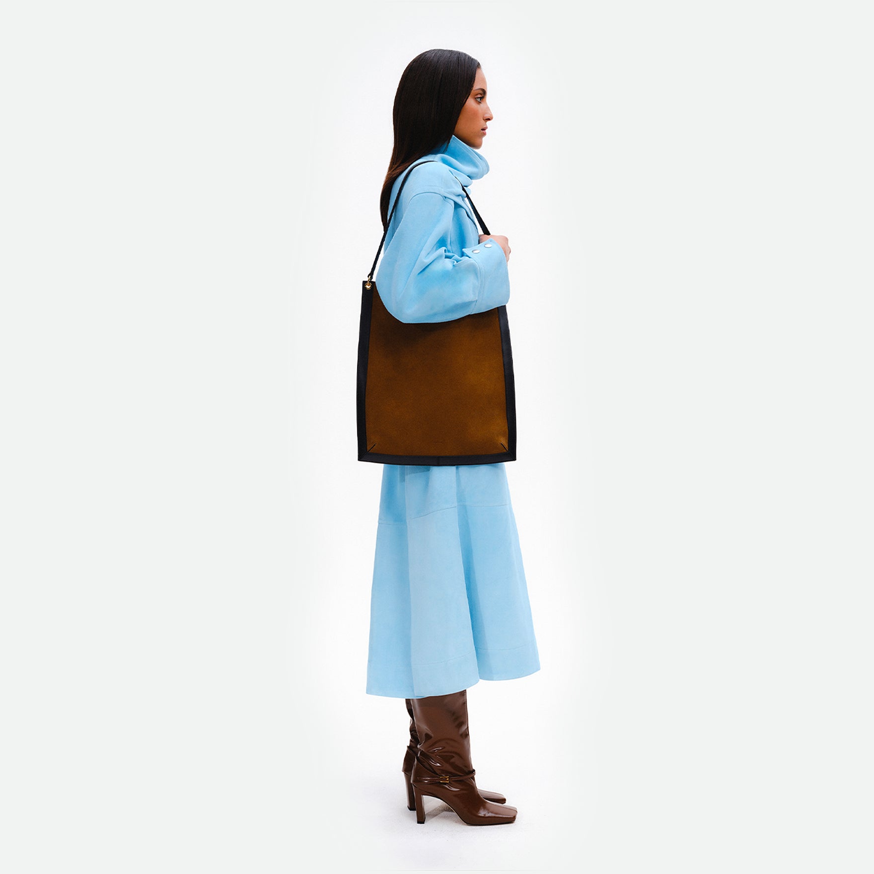 Wandler Penny Tote in the color Tabacco Suede, made from Italian calf leather with hand-painted black edges and golden hardware, pictured being worn on the shoulder by model.