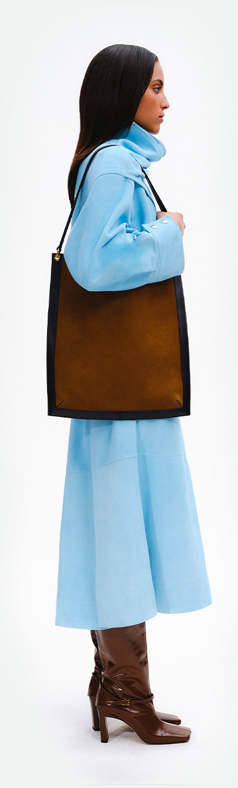 Wandler Penny Tote in the color Tabacco Suede, made from Italian calf leather with hand-painted black edges and golden hardware, pictured being worn on the shoulder by model.