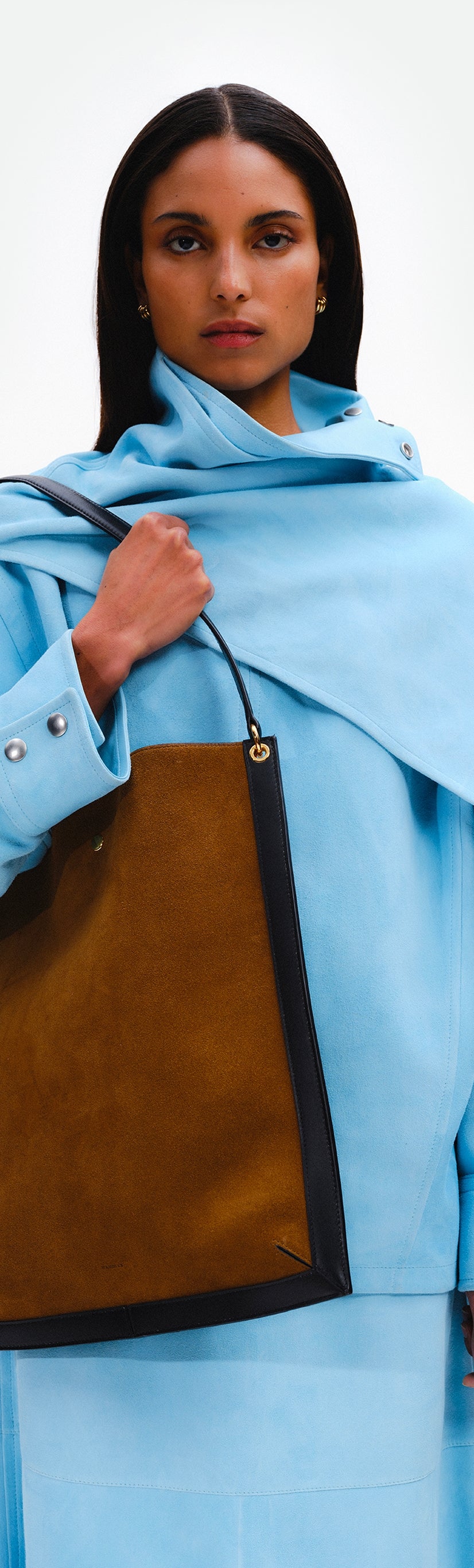 Wandler Penny Tote in the color Tabacco Suede, made from Italian calf leather with hand-painted black edges and golden hardware, pictured being worn on the shoulder by model.