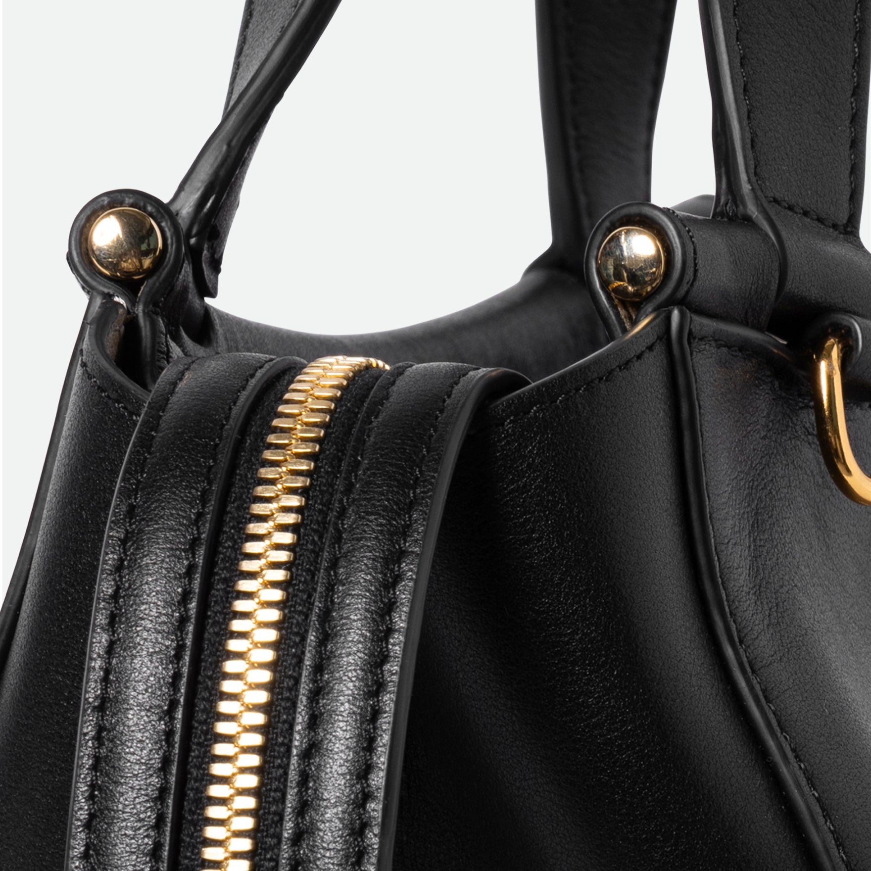 Wandler Ida Bag in the color Black, made from Italian calf leather with golden hardware and sculptural top handle, close up detailing the zipper.