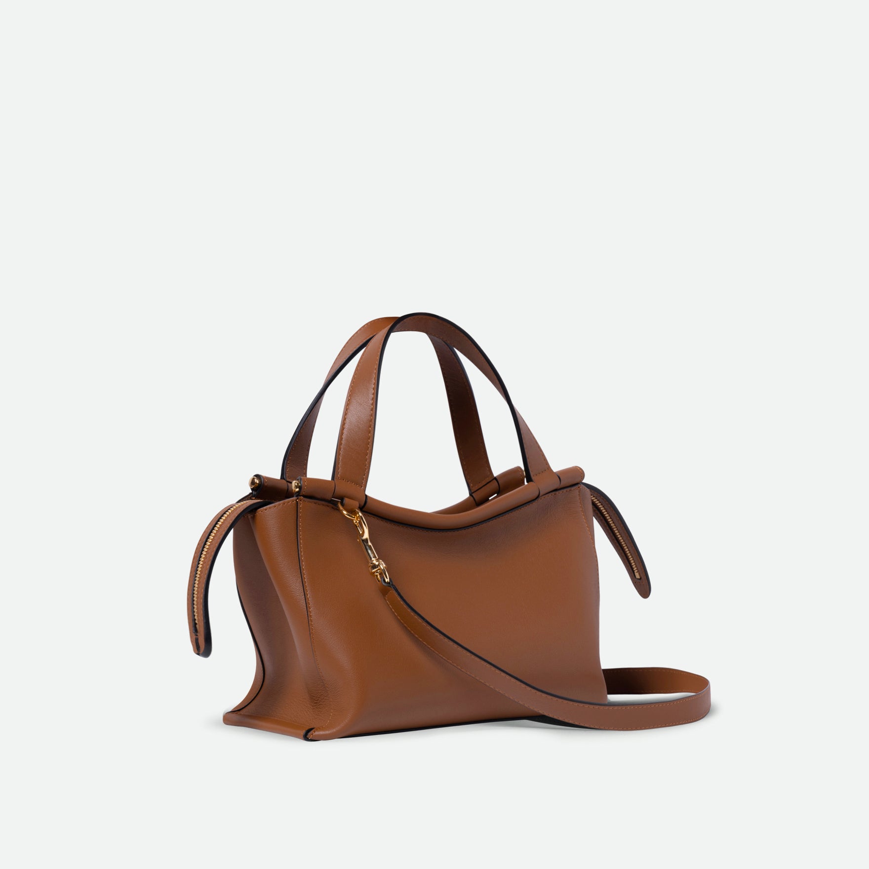 Wandler Ida Bag in the color Saddle, warm brown, made from Italian calf leather with golden hardware and sculptural top handle, three quarters view.