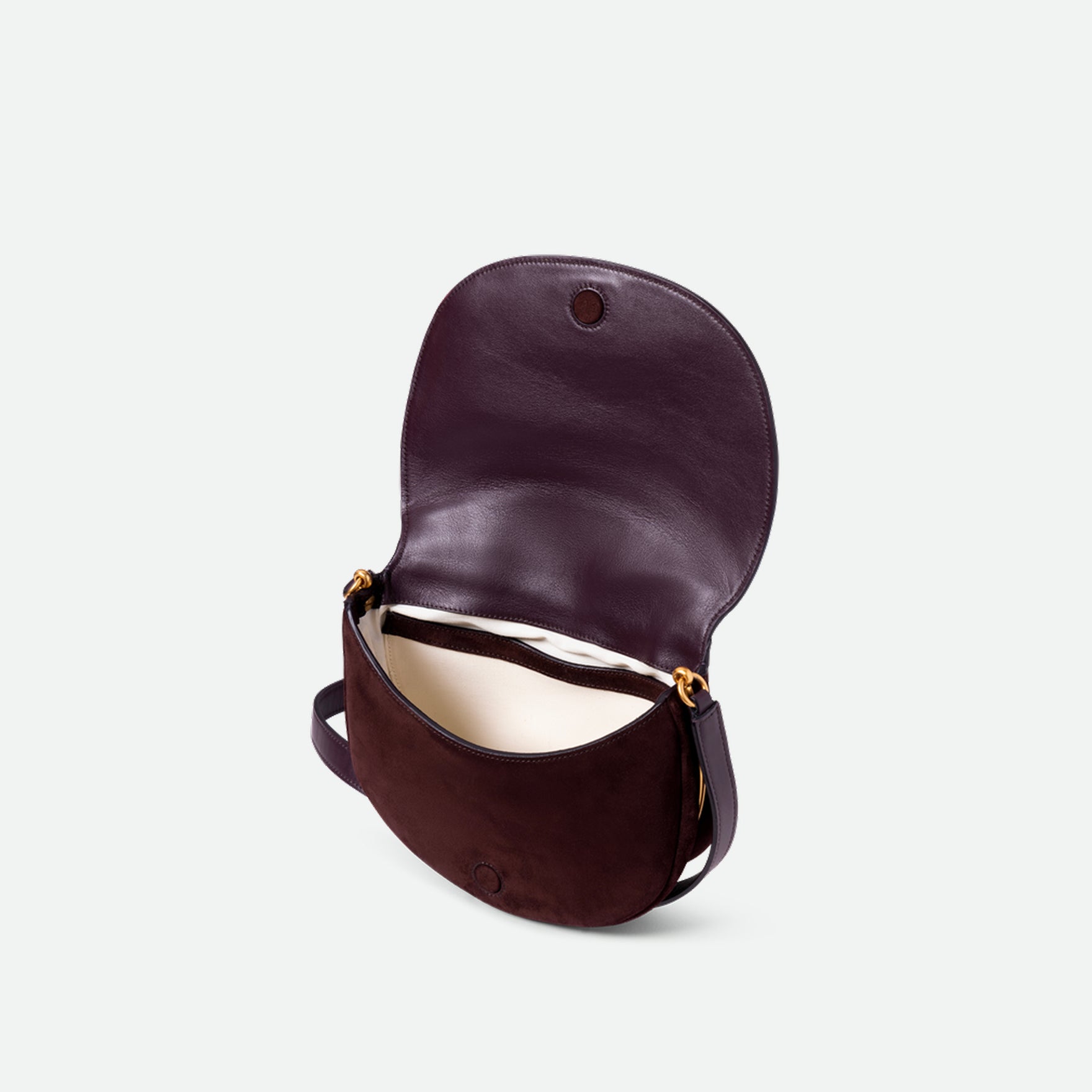Wandler Kate Bag in the color Acai Suede, made from calf leather with golden hardware and adjustable shoulder strap, pictured with the flap of the bag open, allowing for a glimpse of the inside of the bag.
