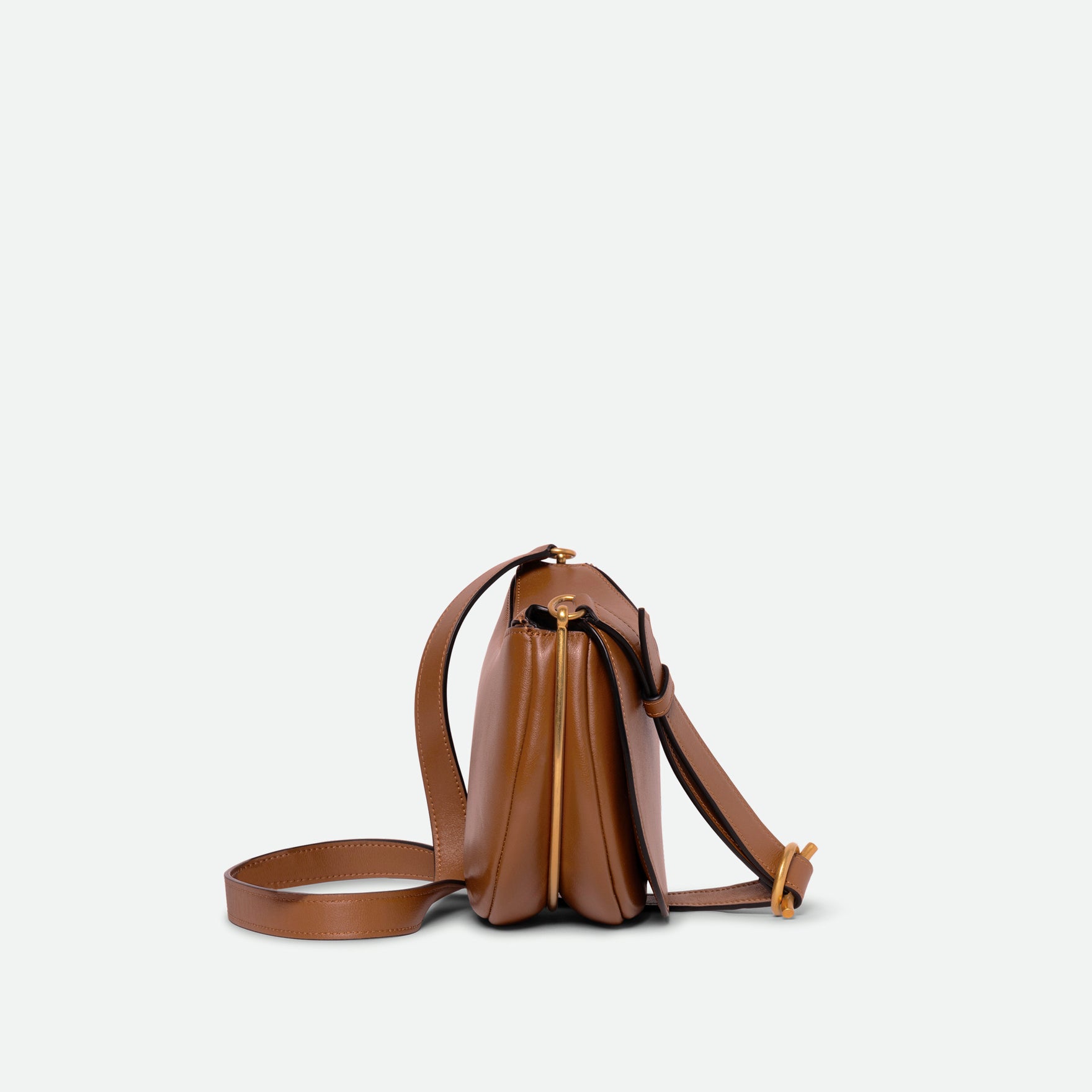 Wandler Kate Saddle Bag in Saddle, made from calf leather with golden hardware and adjustable shoulder strap, side view.