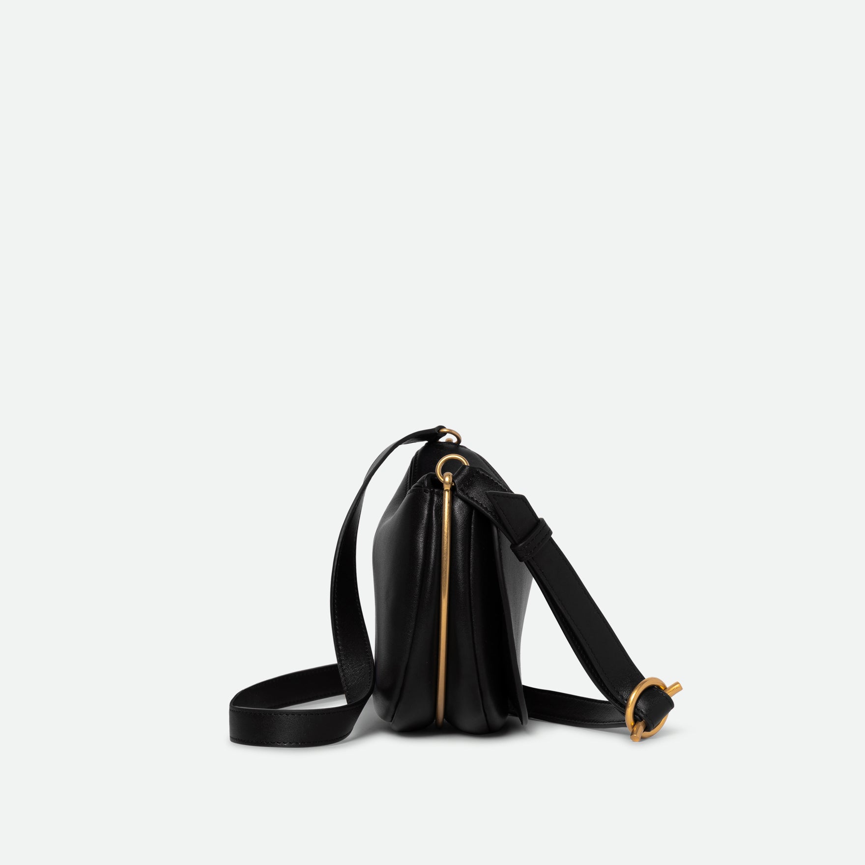 Wandler Kate Bag in the color Black, made from Italian calf leather with golden hardware and adjustable shoulder strap, side view. 