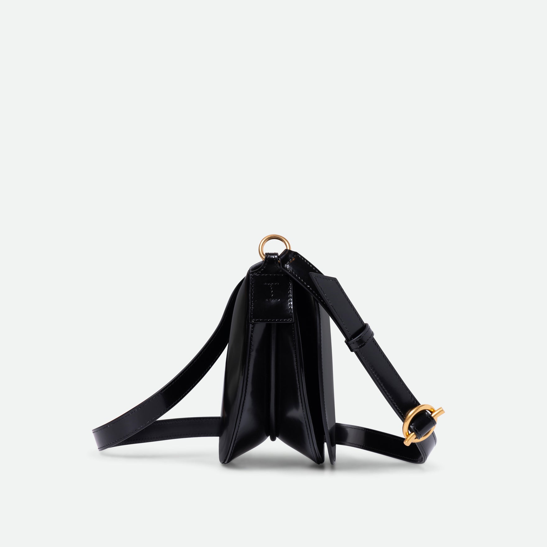 Wandler Kate Saddle Bag in the color Jazz Olive, deep dark green, calf leather with golden hardware and adjustable shoulder strap, side view.