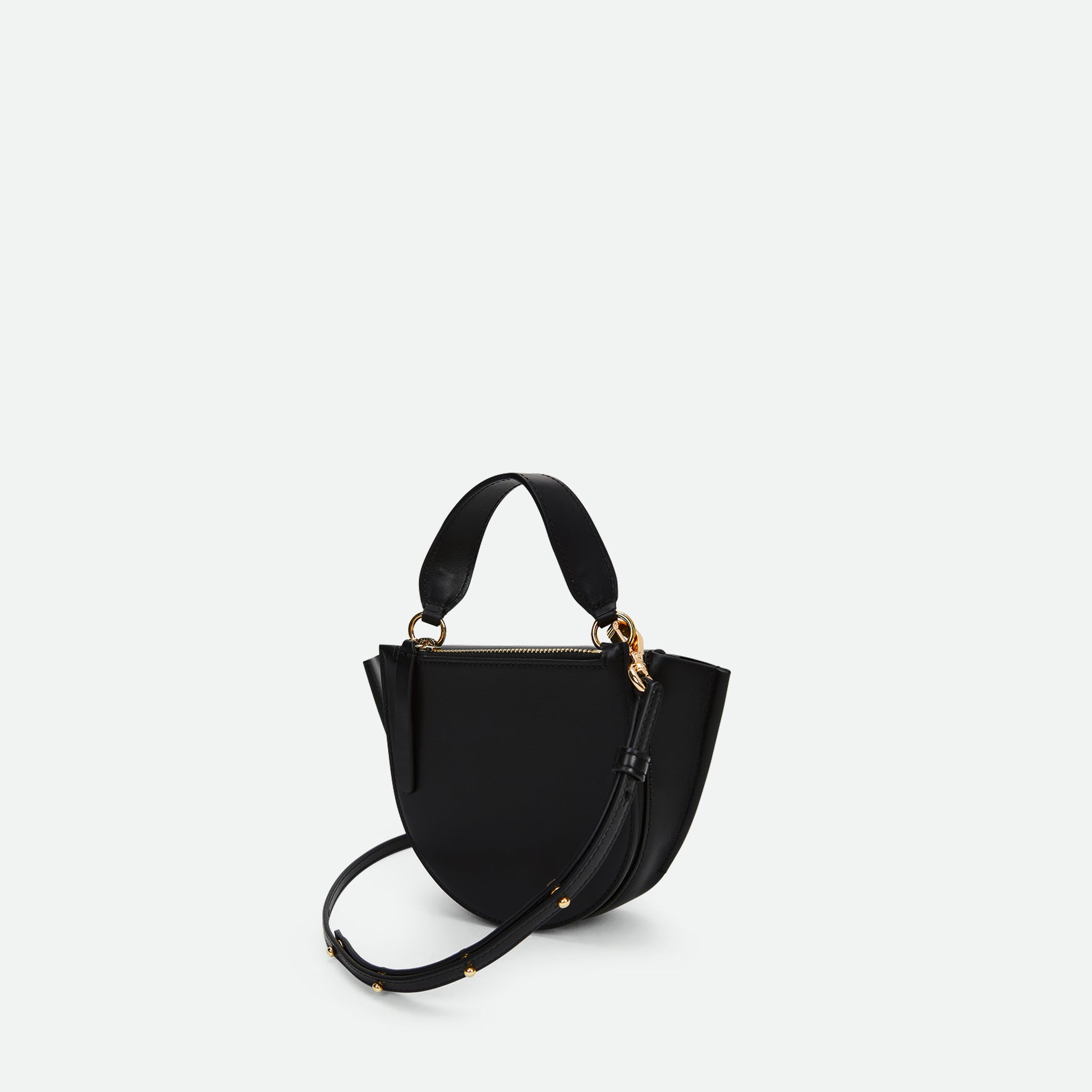 Wandler Hortensia Bag Piccola in the color Black made from Italian calf leather with golden hardware and rounded silhouette, three quarters angle, backside view. 