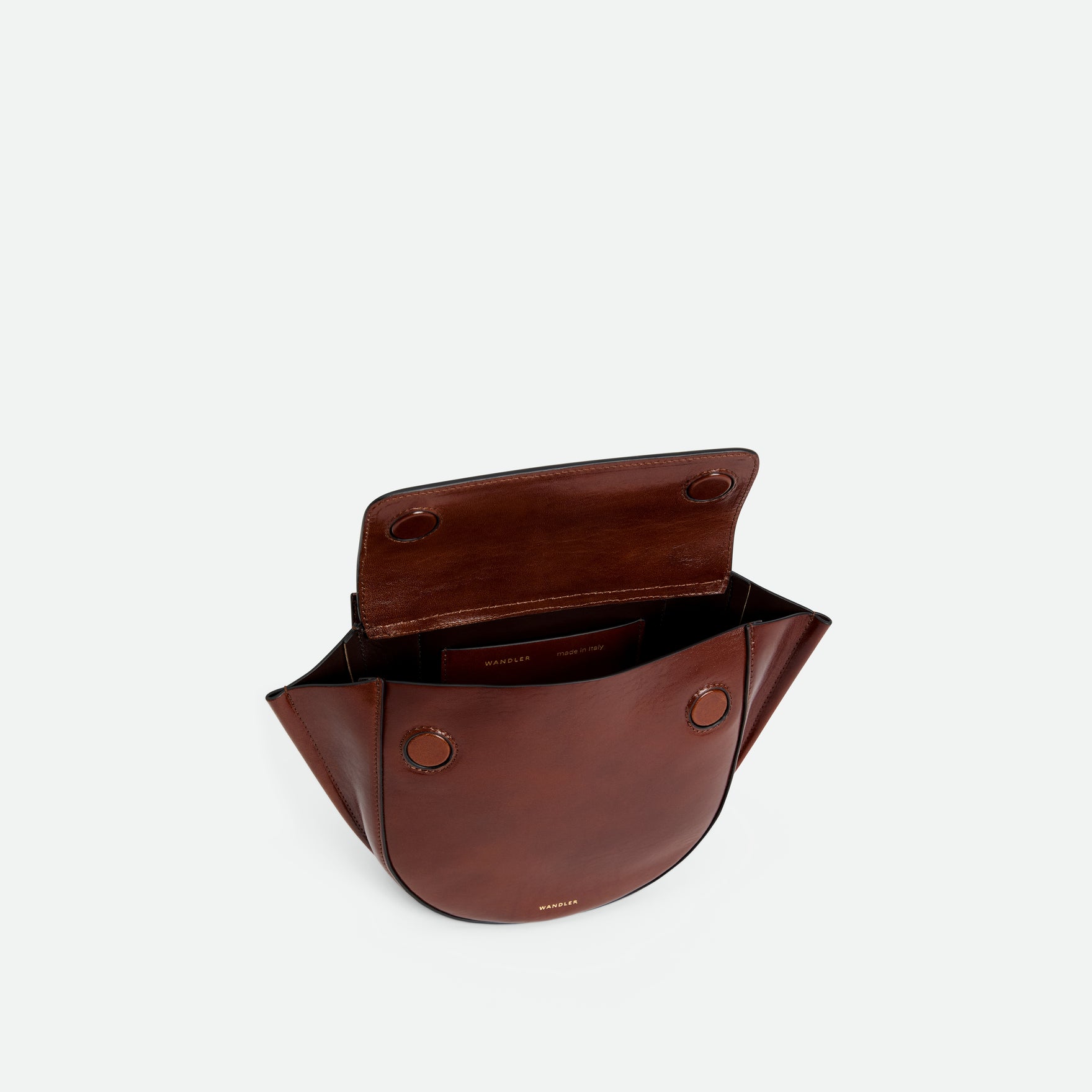 Wandler Hortensia Bag Mini in the color Palissander Glaze, deep dark brown with red undertones, made from Italian calf leather with golden hardware, rounded silhouette and top handle, pictured from above with the flap open, giving a glimpse into the inside of the bag.