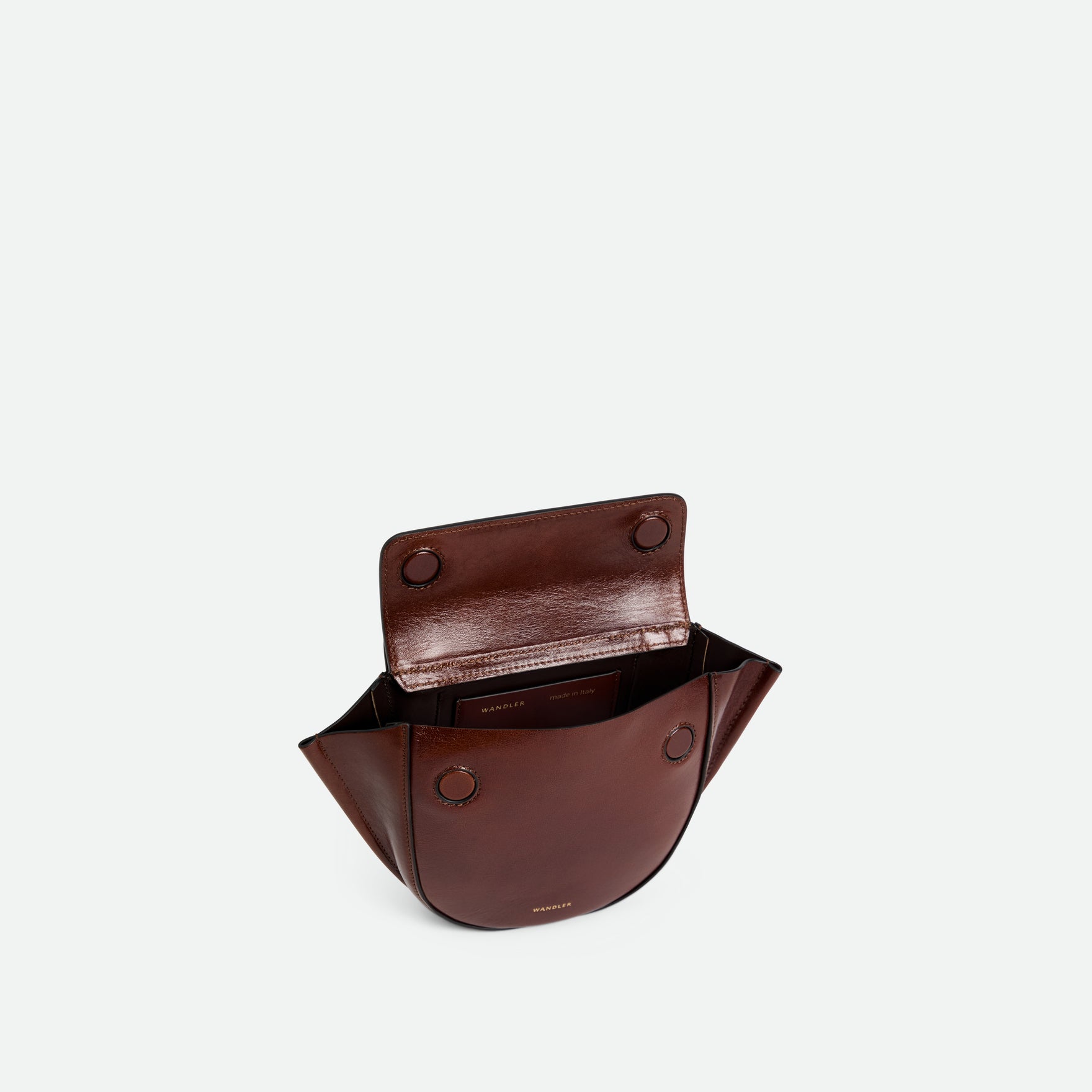 Wandler Hortensia Bag Piccola in the color Palissander Glaze, shiny dark red, made from Italian calf leather with golden hardware and rounded silhouette. The bag is pictured from the front with the flap open, giving a slight view of the inside of the bag.