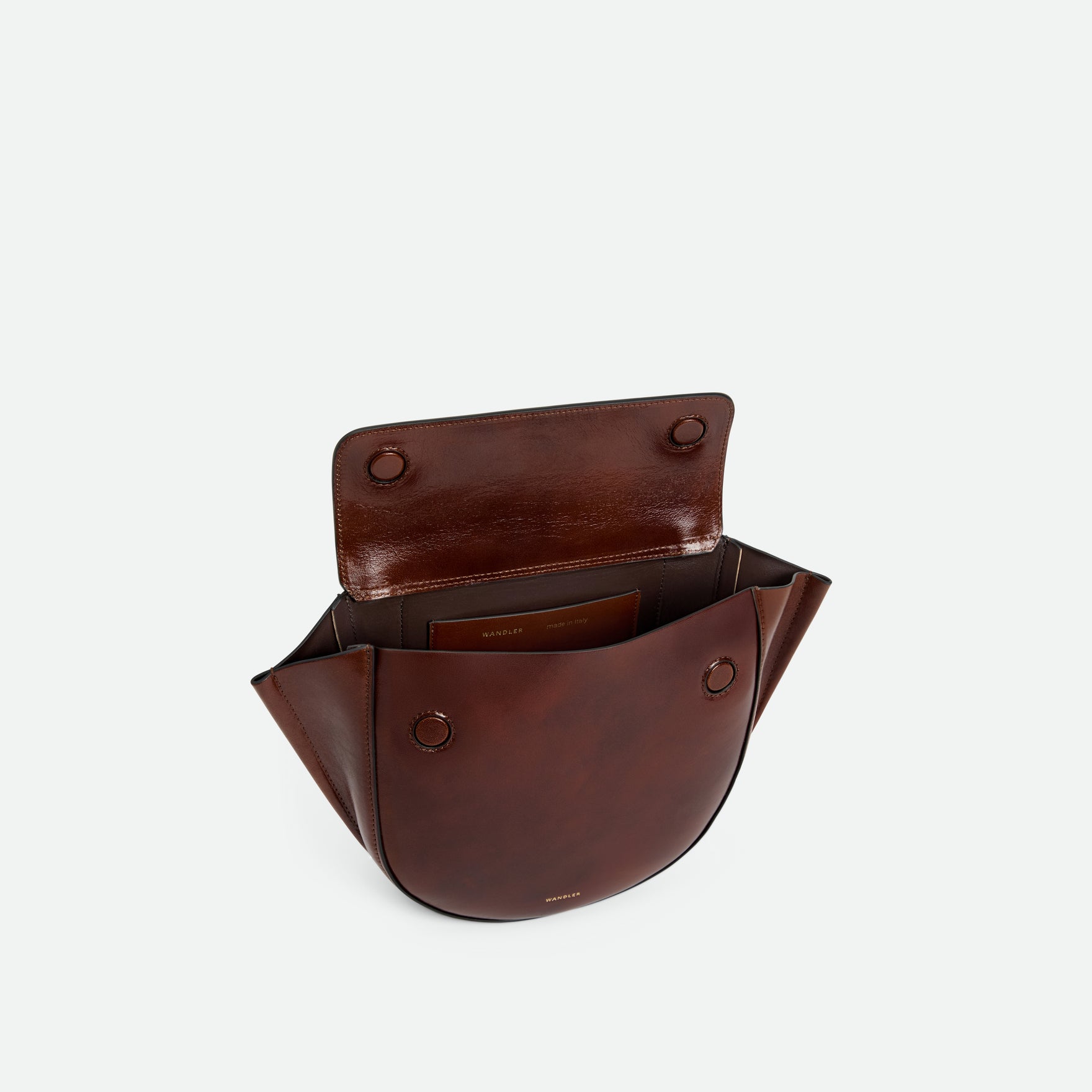 Wandler Hortensia Bag Small in the color Palissander Glaze, deep dark brown with red undertones, Italian calf leather with golden hardware and rounded silhouette. The bag is pictured from the front with the flap open, giving a slight view of the inside of the bag.
