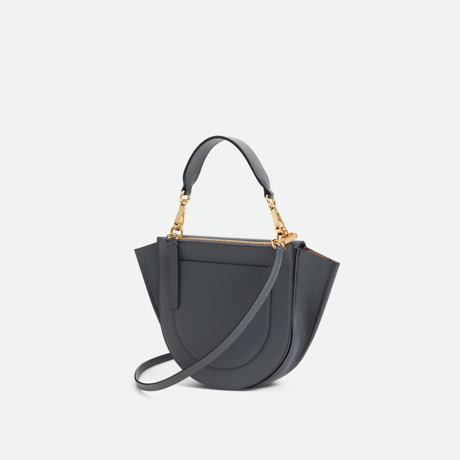 Wandler Hortensia Bag Mini in the color Space, grey, made from Italian calf leather with golden hardware, rounded silhouette and top handle, backside view, three quarters angle. 