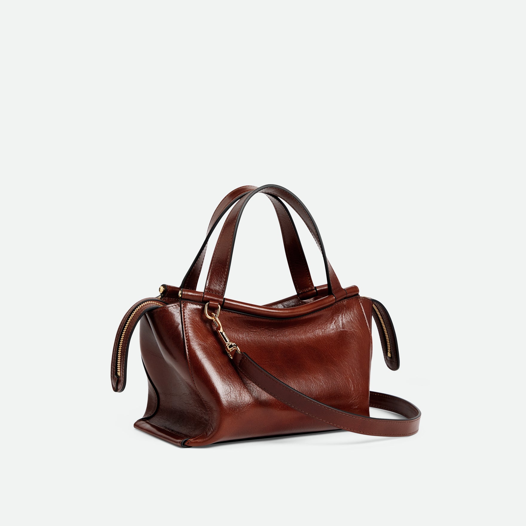 Wandler Ida Bag in the color Palissander Glaze, deep dark brown with red undertones, made from Italian calf leather with golden hardware and sculptural top handle, three quarters view with the crossbody strap attached. 