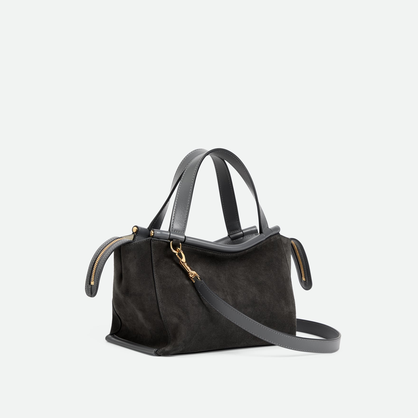 Wandler Ida Bag in the color Space Suede, made from Italian calf leather with golden hardware and sculptural top handle, three quarters angle with crossbody strap attached. 