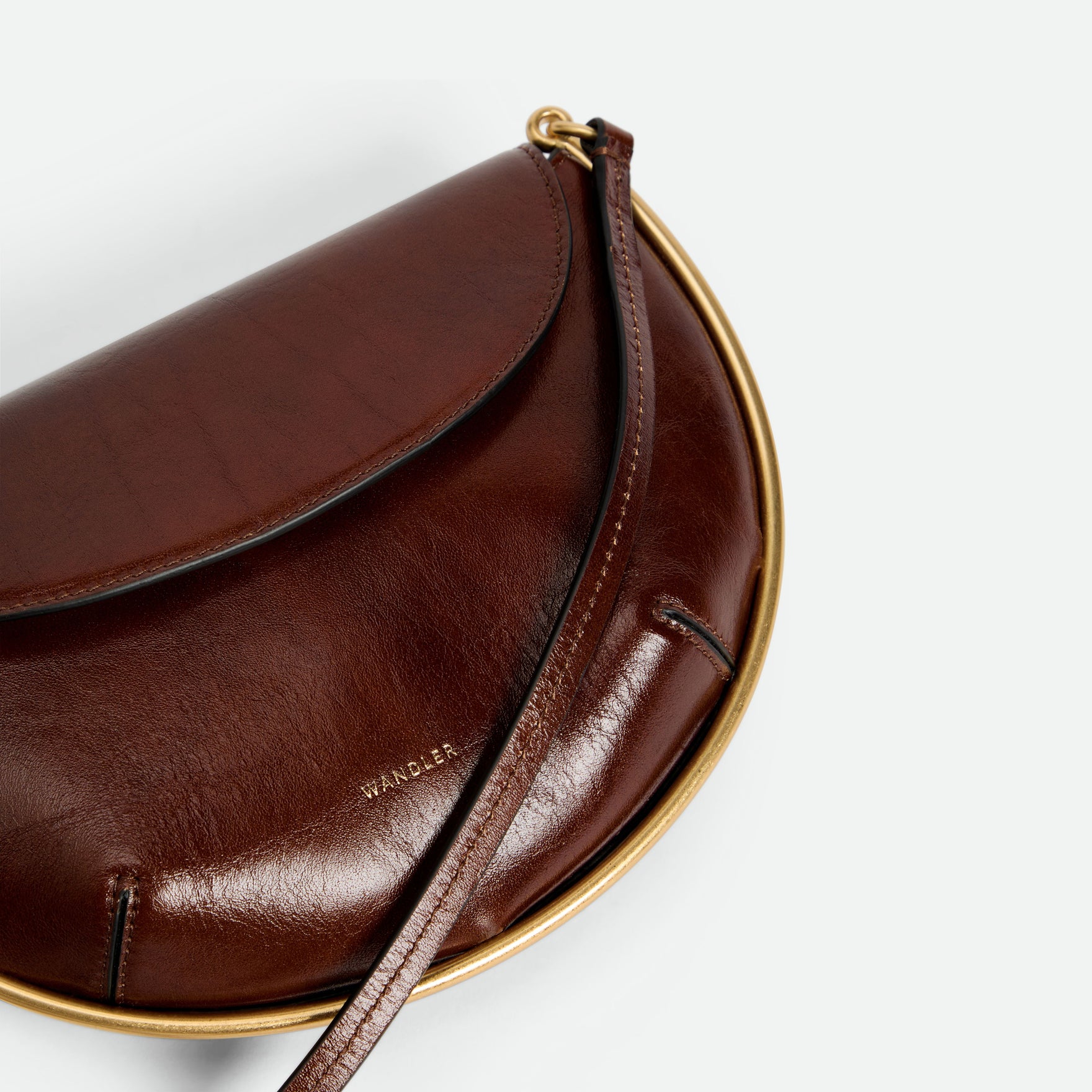 Wandler Kate Mini Crossbody in the color Palissander Glaze, Deep dark brown with red undertones, made from Italian calf leather with golden hardware and adjustable strap, close up detailing the leather and logo. 