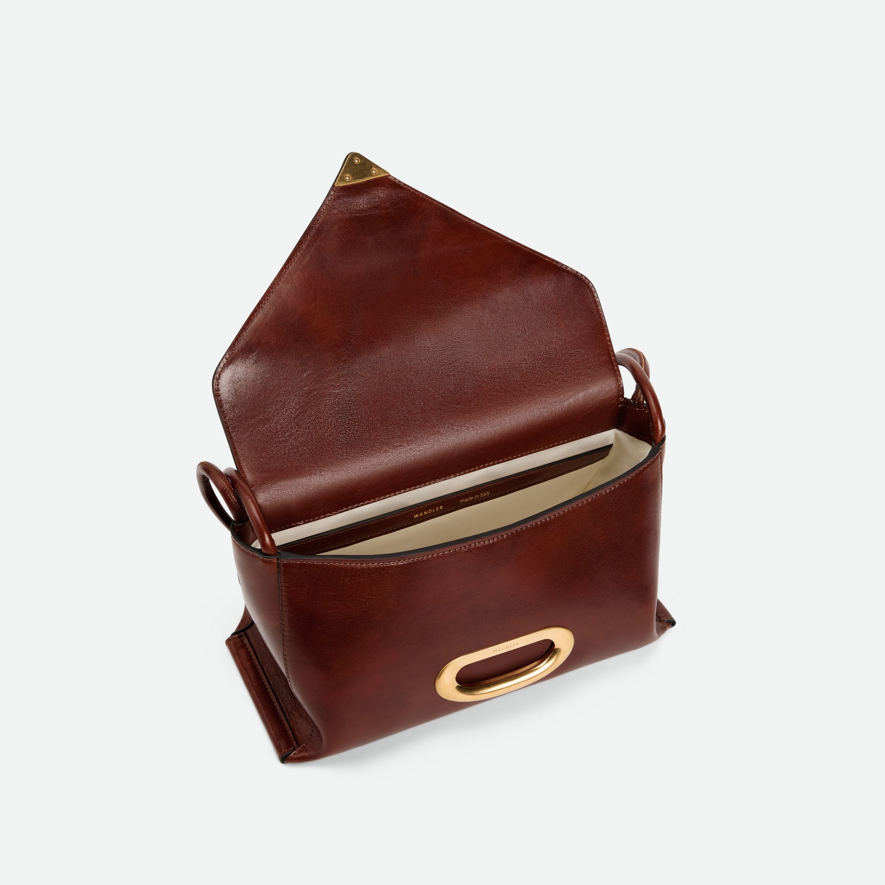 Wandler Veneto Shoulder Bag in the color in Palissander Glaze, deep dark red, Italian calf leather with oversized golden clasp hardware and structured silhouette. The bag is pictured from the front with the flap open, giving a slight view of the inside of the bag.