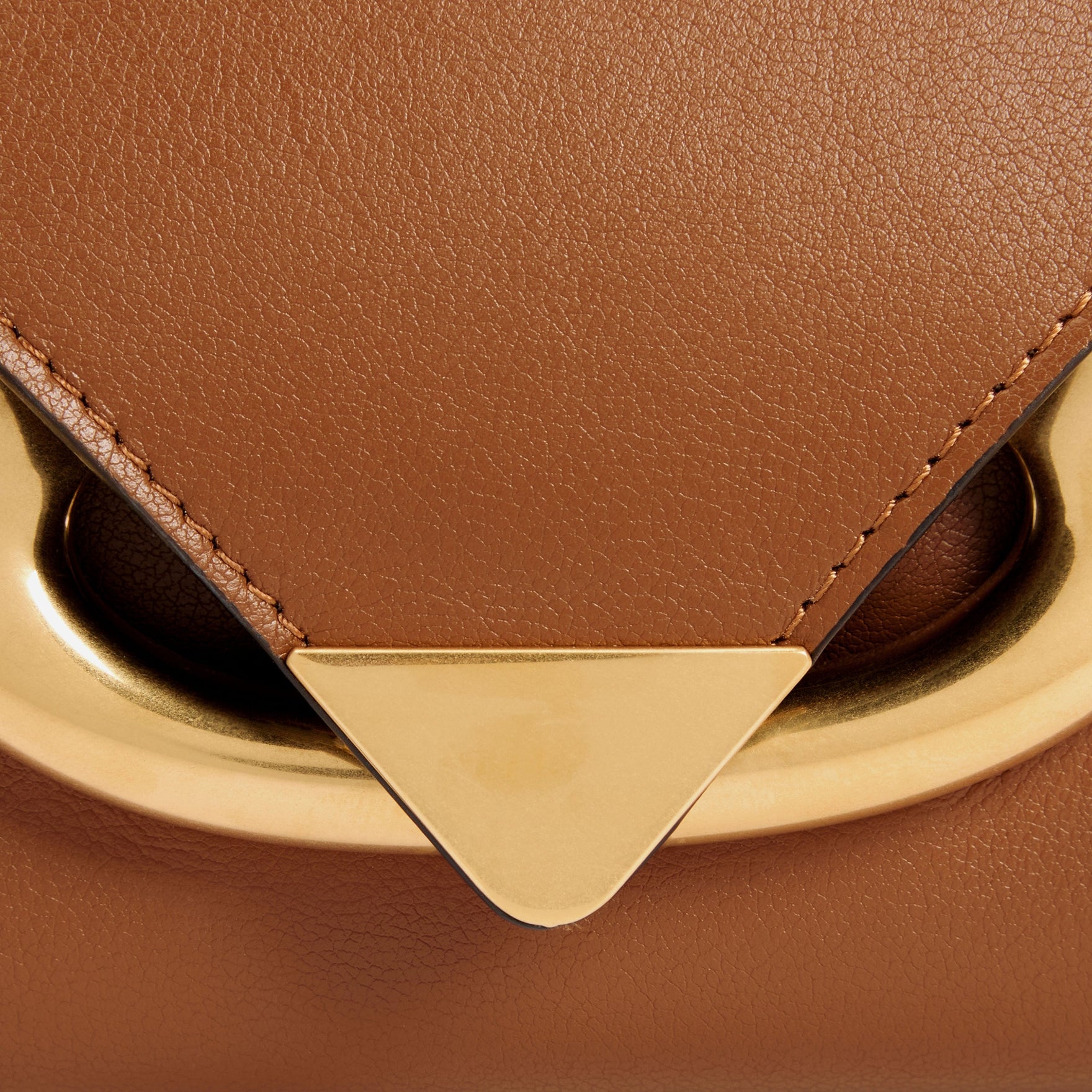 Wandler Veneto Shoulder Bag in the color Saddle, warm brown, Italian calf leather with oversized golden clasp hardware and structured silhouette, close up detailing clasp and leather. 