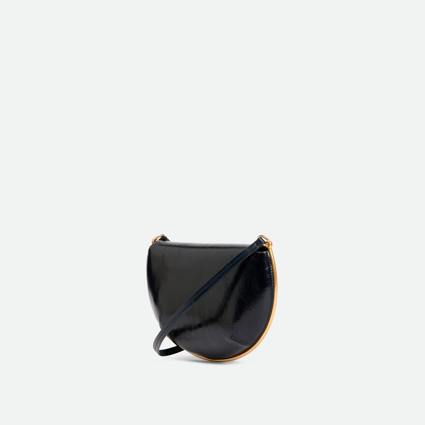 Wandler Kate Mini Crossbody in the color Orion Glaze, deep dark blue, made from Italian calf leather with golden hardware and adjustable strap, backside view, three quarters angle.