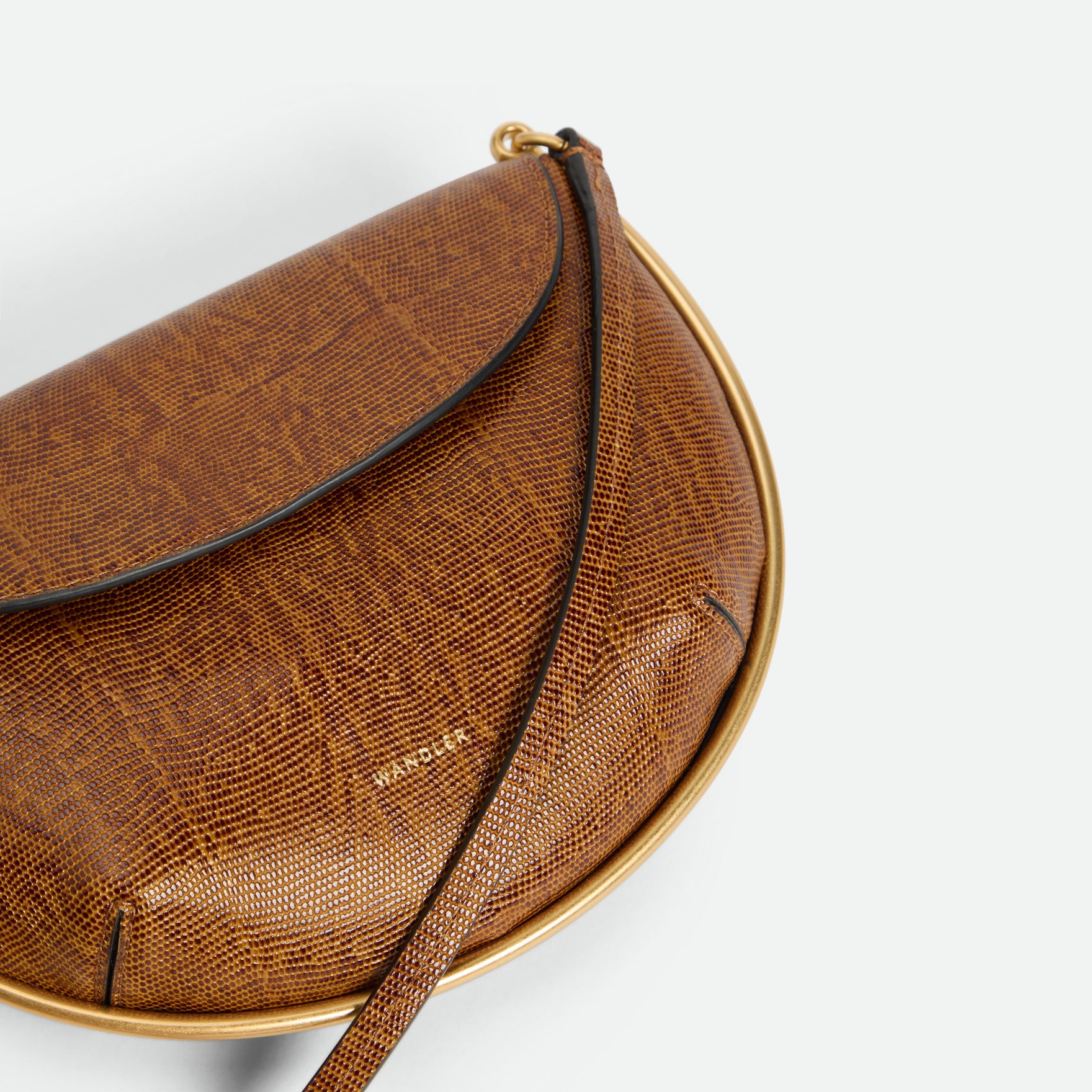Wandler Kate Mini Crossbody in the color Tabacco Lizzard, Warm brown with lizzard motive, made from Italian calf leather with golden hardware and adjustable strap, close up detailing logo and leather. 