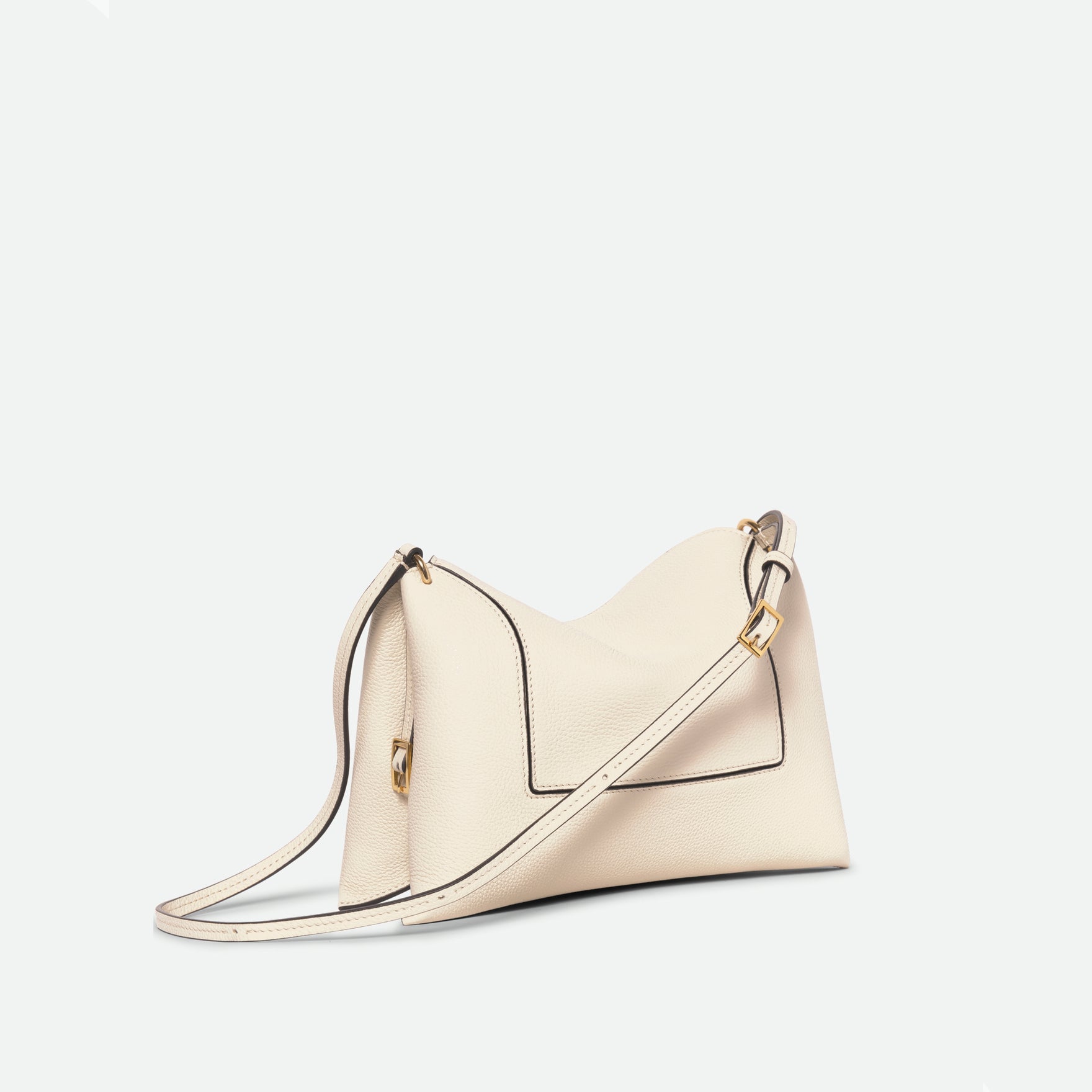 Wandler Penelope Slouch Bag in the colour Beige Crust, beige, made from smooth calf leather with golden hardware and adjustable slim strap, three-quarter view, side and front of the bag is shown. 
